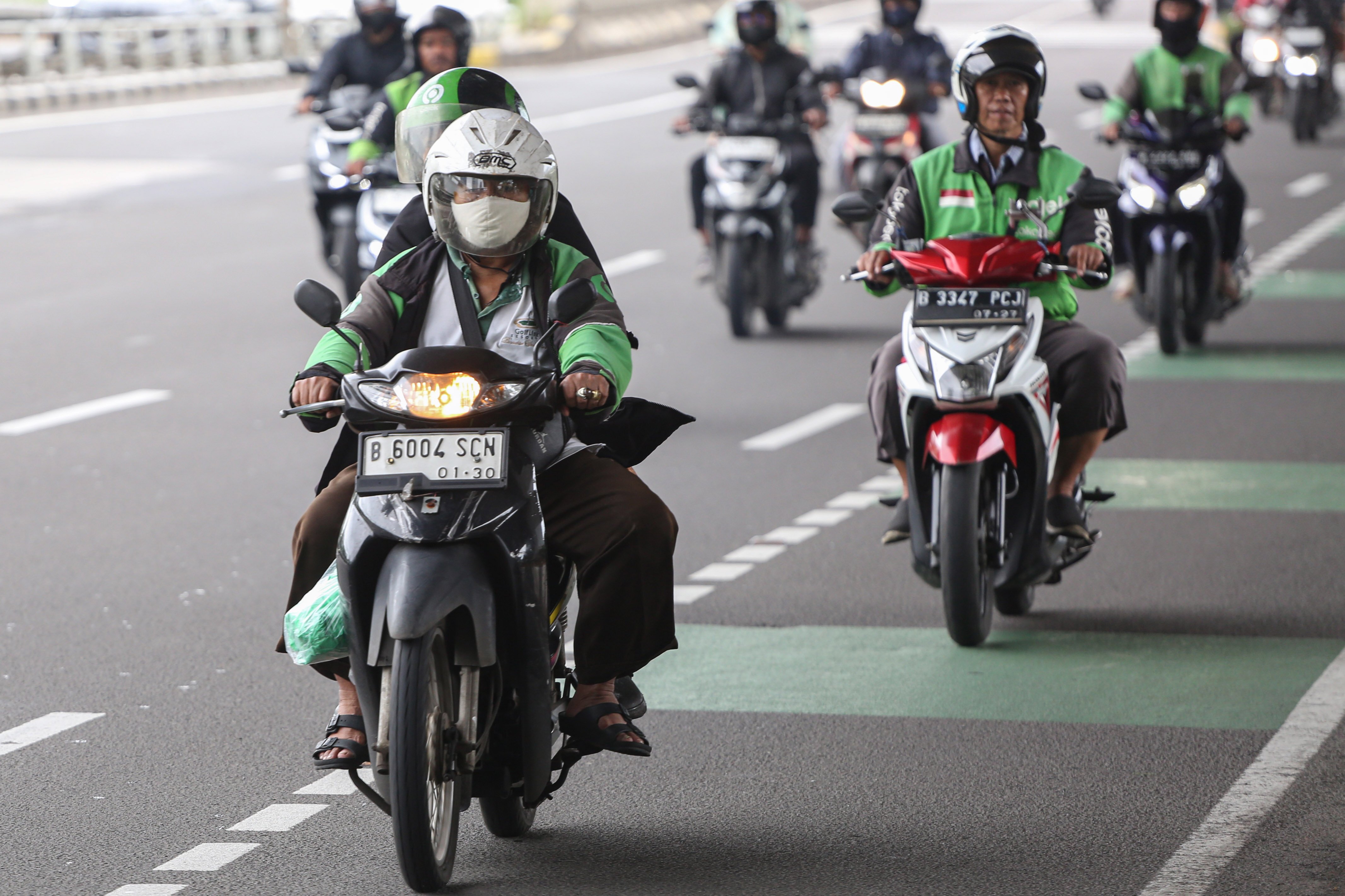 Pengemudi ojek online (ojol) membawa penumpang di Jalan Gatot Subroto, Jakarta, Kamis (5/3/2026). Pemerintah menetapkan besaran Bonus Hari Raya atau BHR untuk mitra pengemudi taksi online dan ojol yakni 25% dari rata-rata pendapatan bersih selama 12 bulan terakhir.