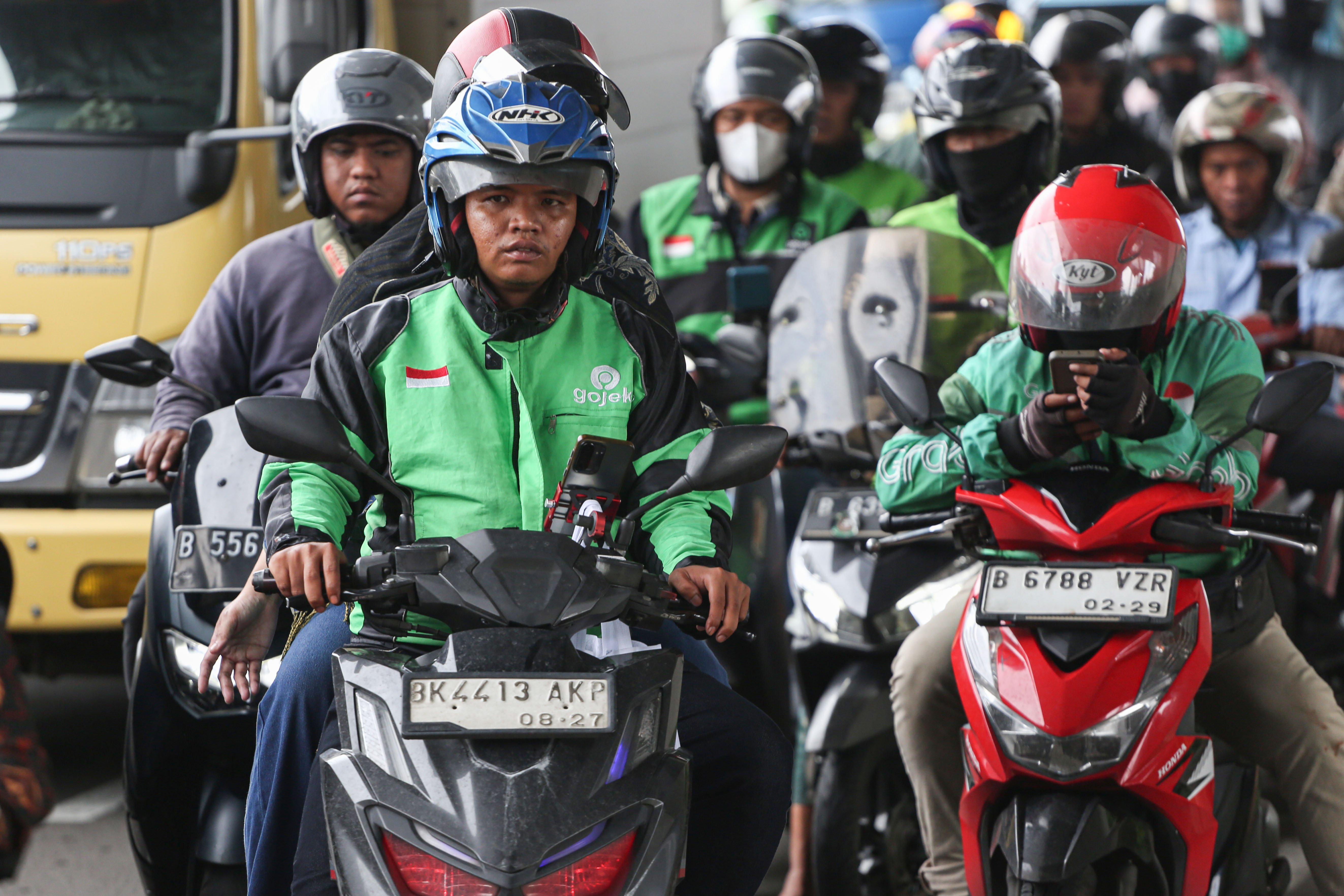 Pengemudi ojek online (ojol) membawa penumpang di Jalan Gatot Subroto, Jakarta, Kamis (5/3/2026). Pemerintah menetapkan besaran Bonus Hari Raya atau BHR untuk mitra pengemudi taksi online dan ojol yakni 25% dari rata-rata pendapatan bersih selama 12 bulan terakhir.