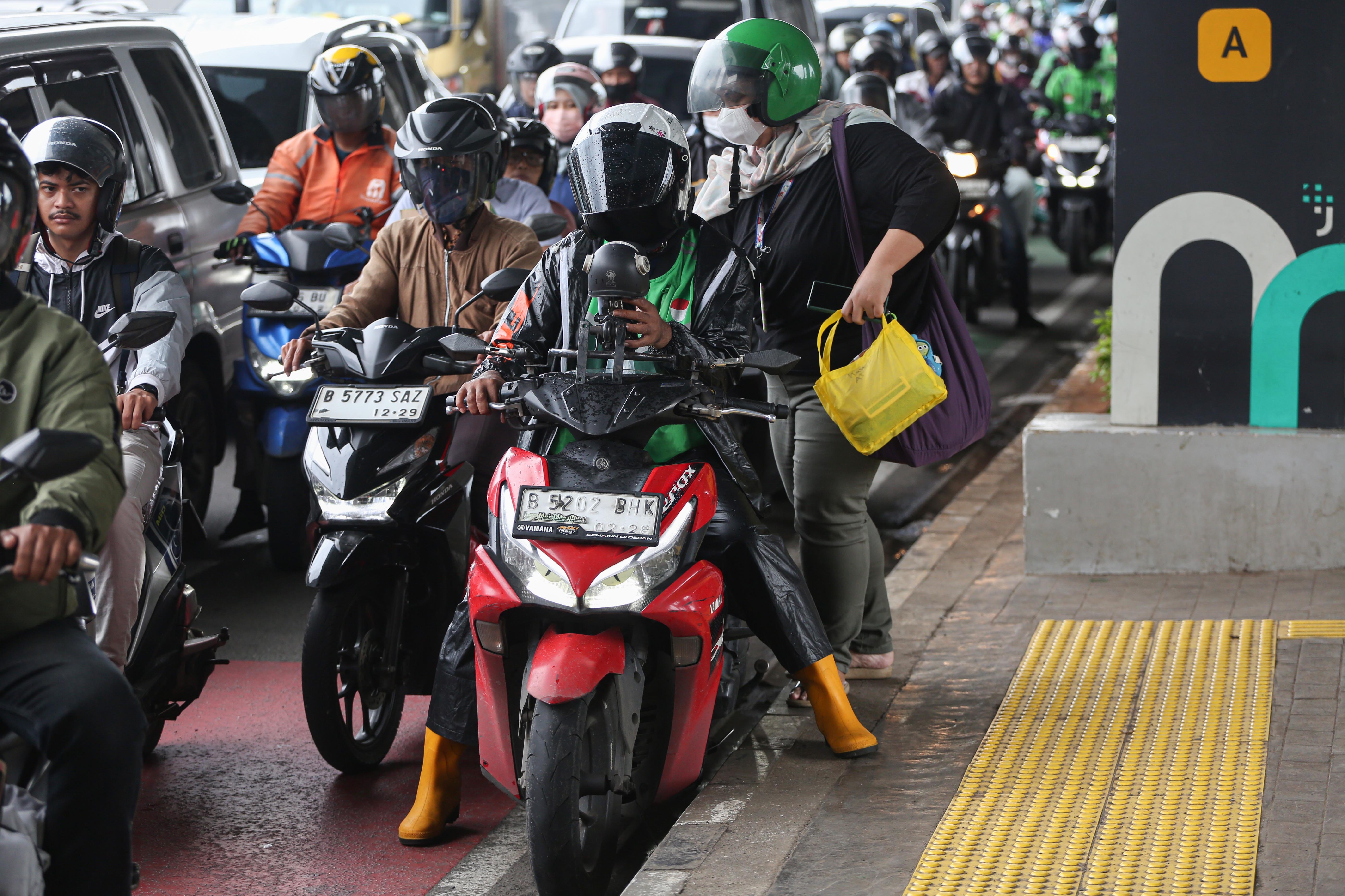 Pengemudi ojek online (ojol) membawa penumpang di Jalan Gatot Subroto, Jakarta, Kamis (5/3/2026). Pemerintah menetapkan besaran Bonus Hari Raya atau BHR untuk mitra pengemudi taksi online dan ojol yakni 25% dari rata-rata pendapatan bersih selama 12 bulan terakhir.