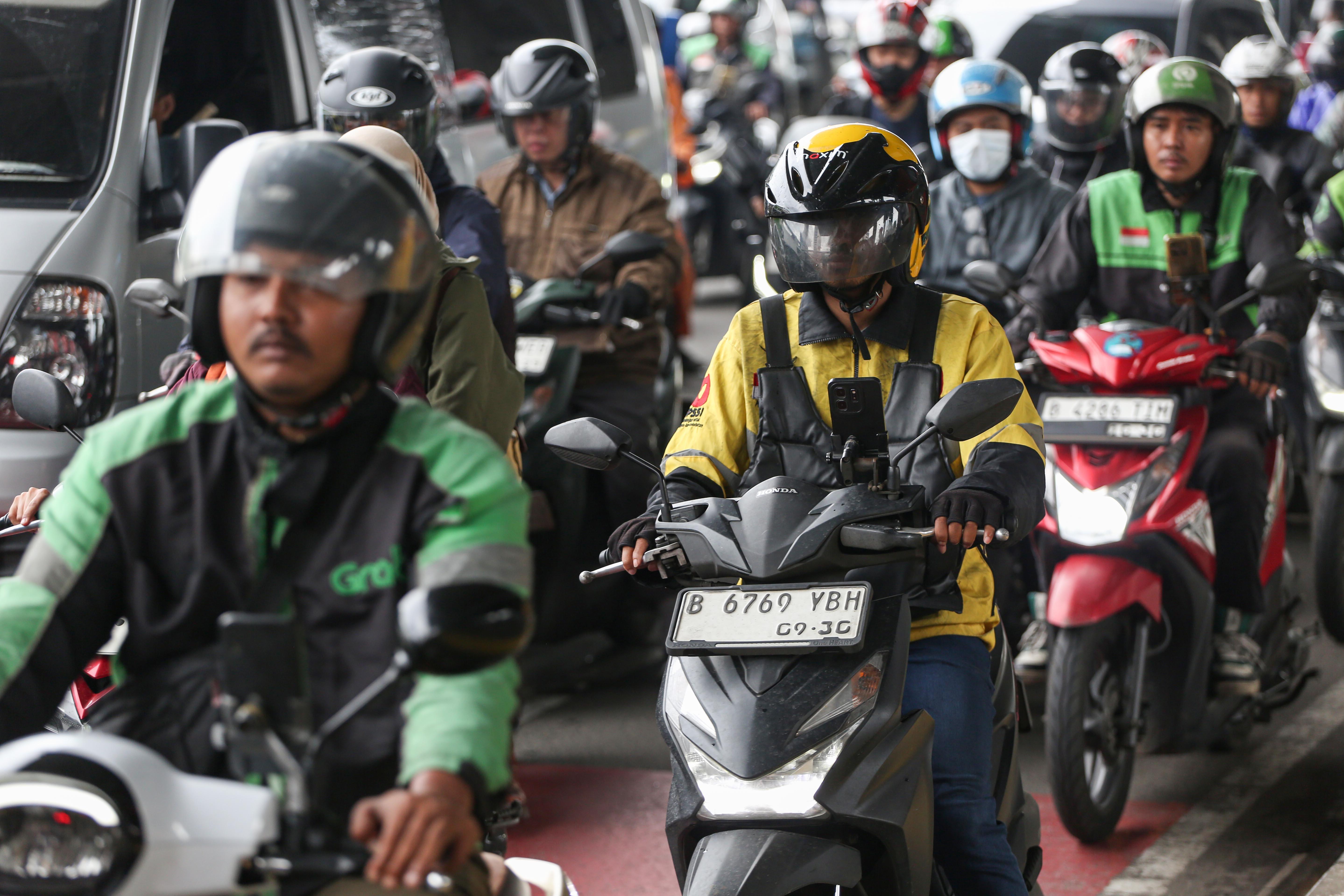 Pengemudi ojek online (ojol) melintas di Jalan Gatot Subroto, Jakarta, Kamis (5/3/2026). Pemerintah menetapkan besaran Bonus Hari Raya atau BHR untuk mitra pengemudi taksi online dan ojol yakni 25% dari rata-rata pendapatan bersih selama 12 bulan terakhir.