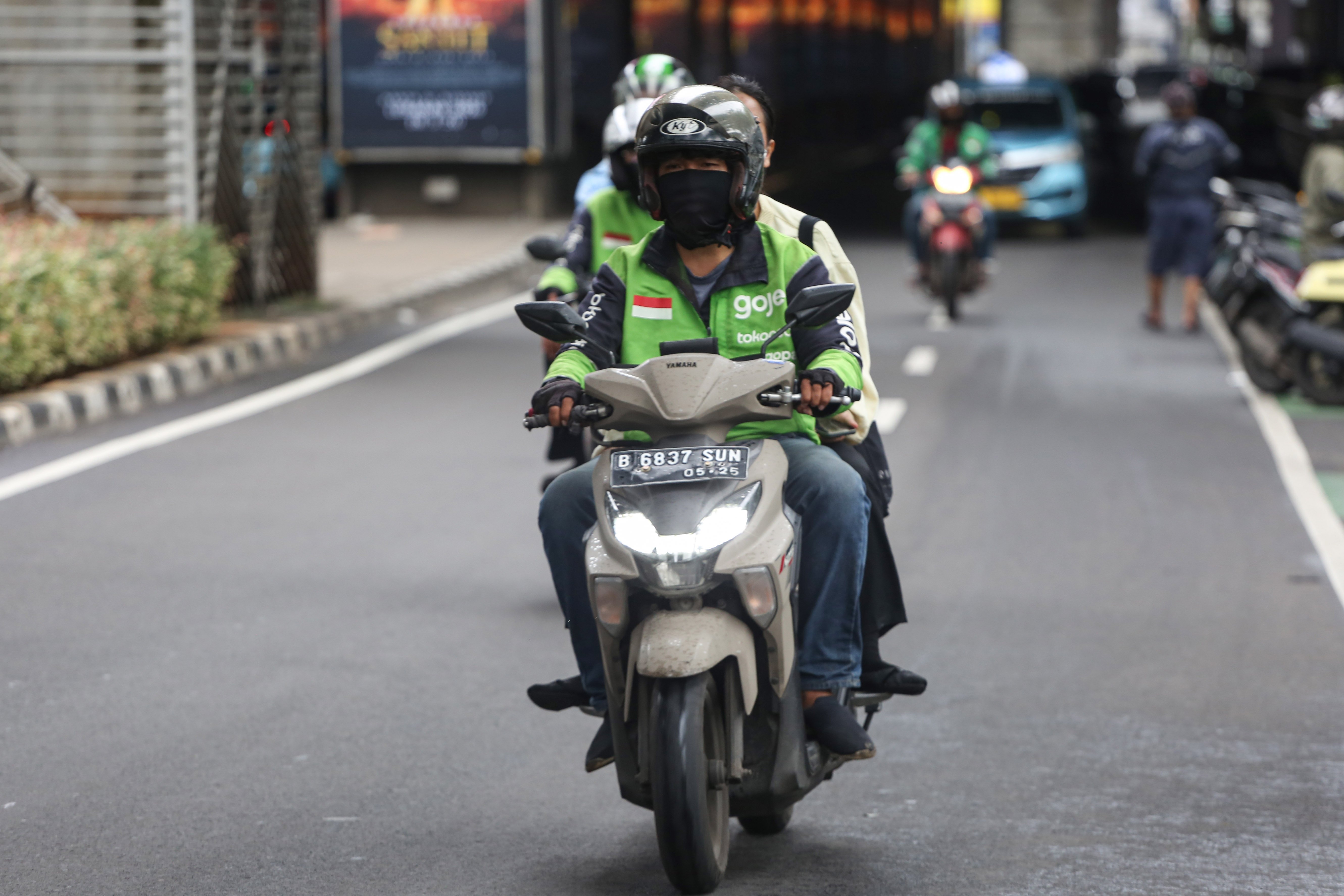 Pengemudi ojek online (ojol) membawa penumpang di Jalan Panglima Polim, Blok M, Jakarta, Kamis (5/3/2026). Pemerintah menetapkan besaran Bonus Hari Raya atau BHR untuk mitra pengemudi taksi online dan ojol yakni 25% dari rata-rata pendapatan bersih selama 12 bulan terakhir.