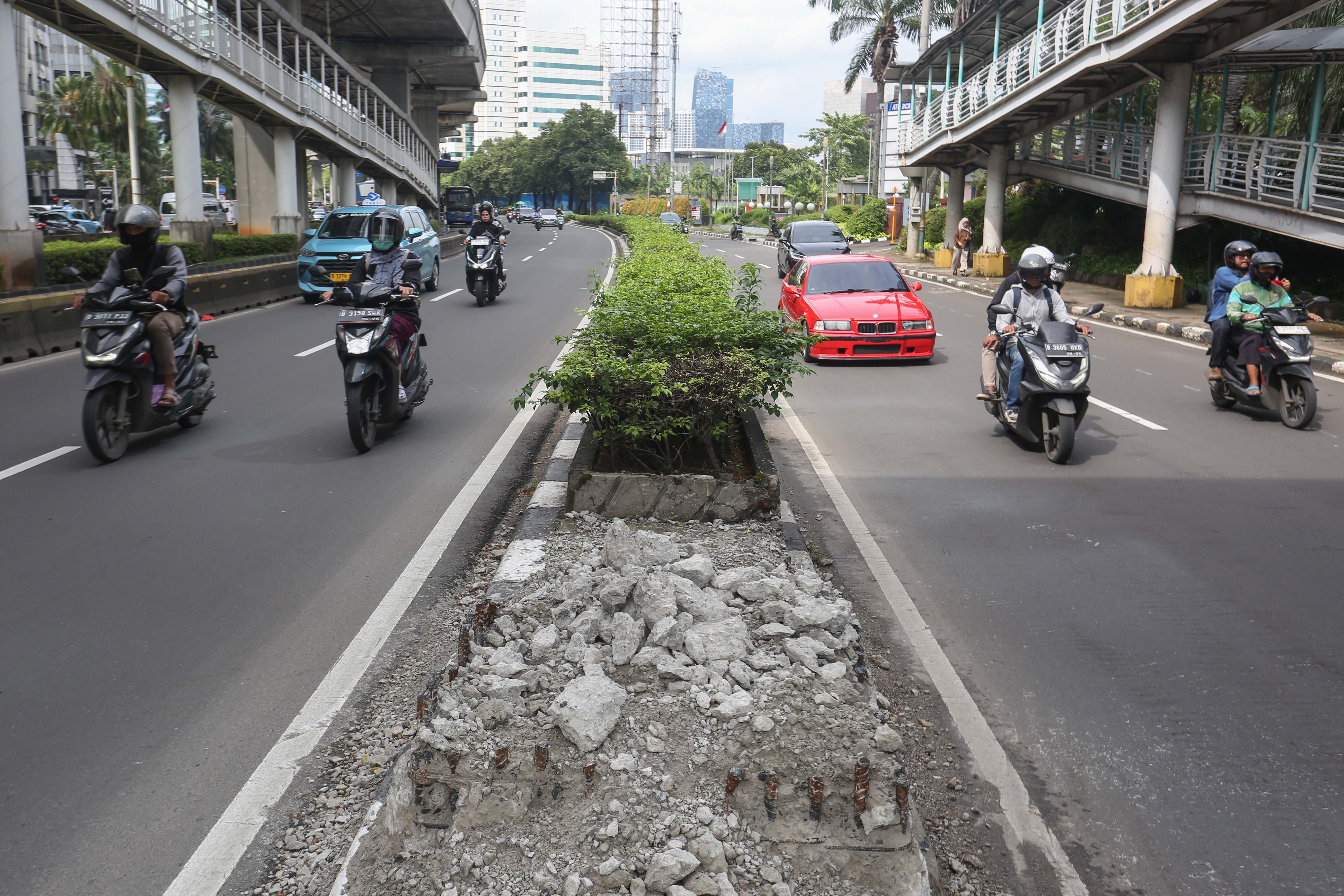 Pengendara melintas di dekat puing dari tiang monorel yang sudah dibongkar di Jalan H.R. Rasuna Said, Kuningan, Jakarta, Jumat (6/3/2026). Pemerintah Provinsi DKI Jakarta telah membongkar 109 tiang monorel yang mangkrak dan selanjutnya akan melakukan penataan dengan membangun ruas jalan, taman hingga pedestrian untuk meningkatkan keindahan kota dan mengurangi kemacetan yang kerap terjadi di kawasan tersebut.