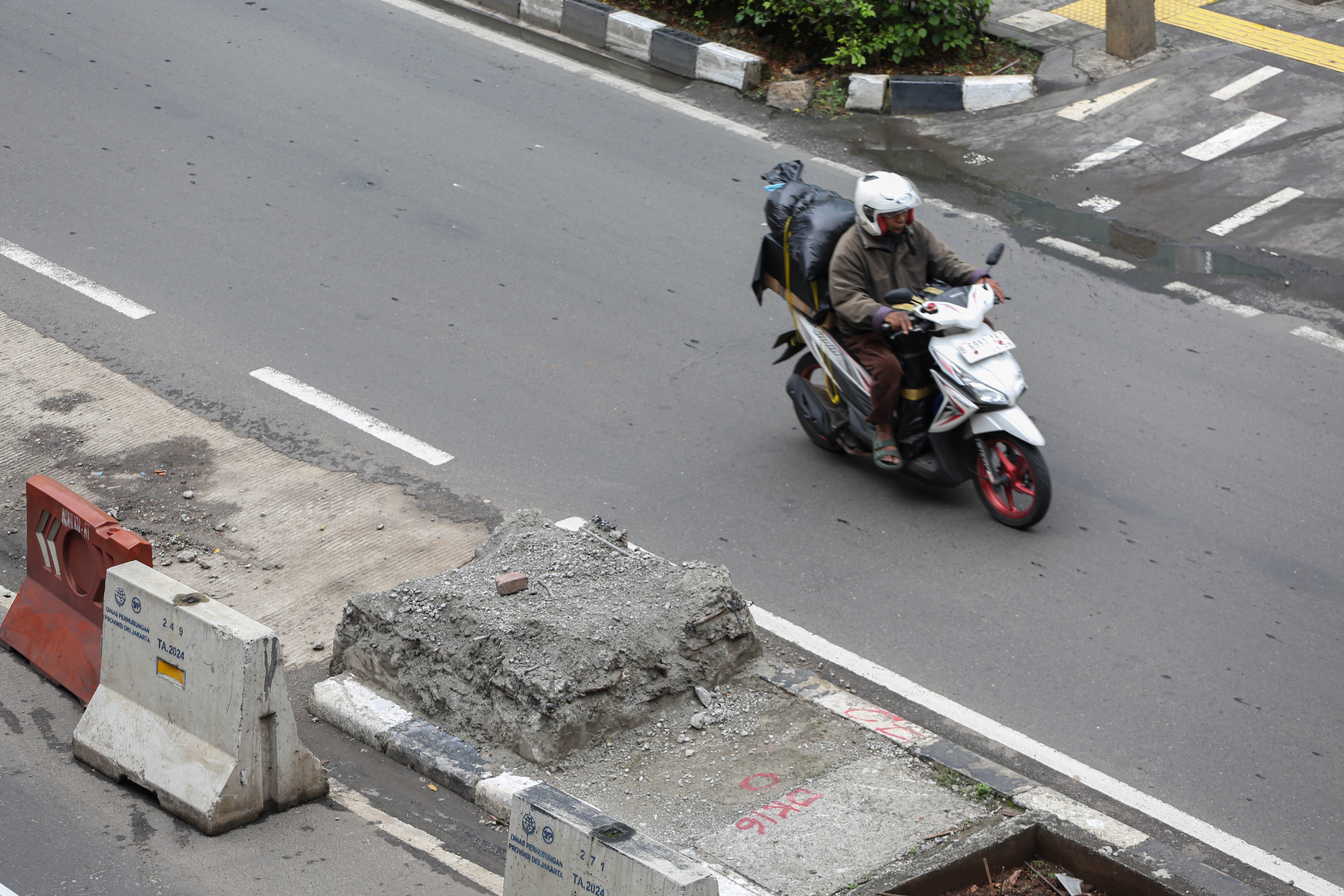 Pengendara melintas di dekat puing dari tiang monorel yang sudah dibongkar di Jalan H.R. Rasuna Said, Kuningan, Jakarta, Jumat (6/3/2026). Pemerintah Provinsi DKI Jakarta telah membongkar 109 tiang monorel yang mangkrak dan selanjutnya akan melakukan penataan dengan membangun ruas jalan, taman hingga pedestrian untuk meningkatkan keindahan kota dan mengurangi kemacetan yang kerap terjadi di kawasan tersebut.