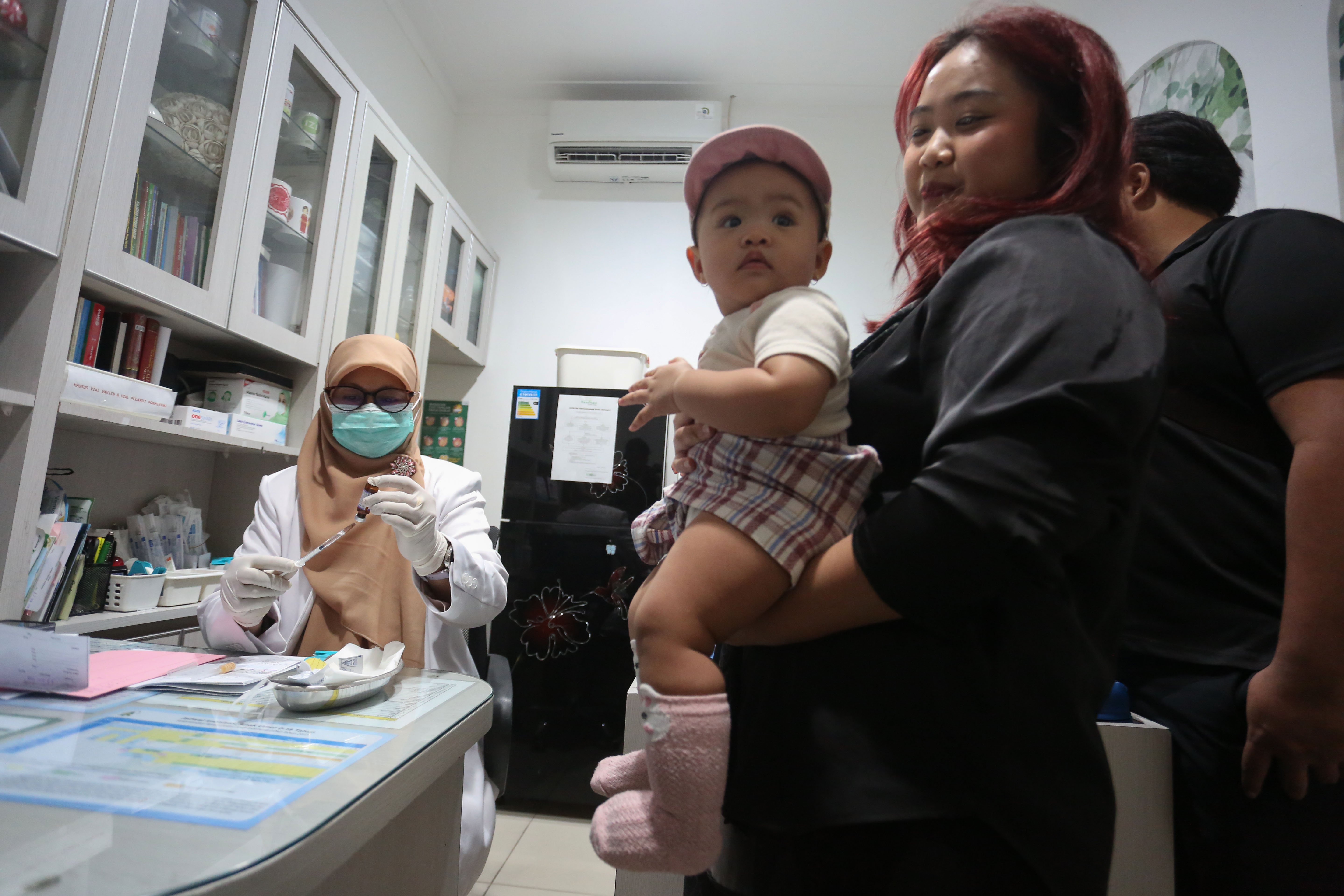 Orang tua mendampingi anaknya yang mengikuti program vaksinasi campak gratis di Rumah Vaksinasi Pusat, Kramat Jati, Jakarta Timur, Kamis (12/3/2026). Kegiatan yang ditujukan bagi anak usia 9 hingga 59 bulan atau anak usia di bawah lima tahun ini digelar sebagai langkah perlindungan optimal pada anak terhadap kasus campak yang dalam beberapa waktu terakhir menunjukkan peningkatan signifikan.