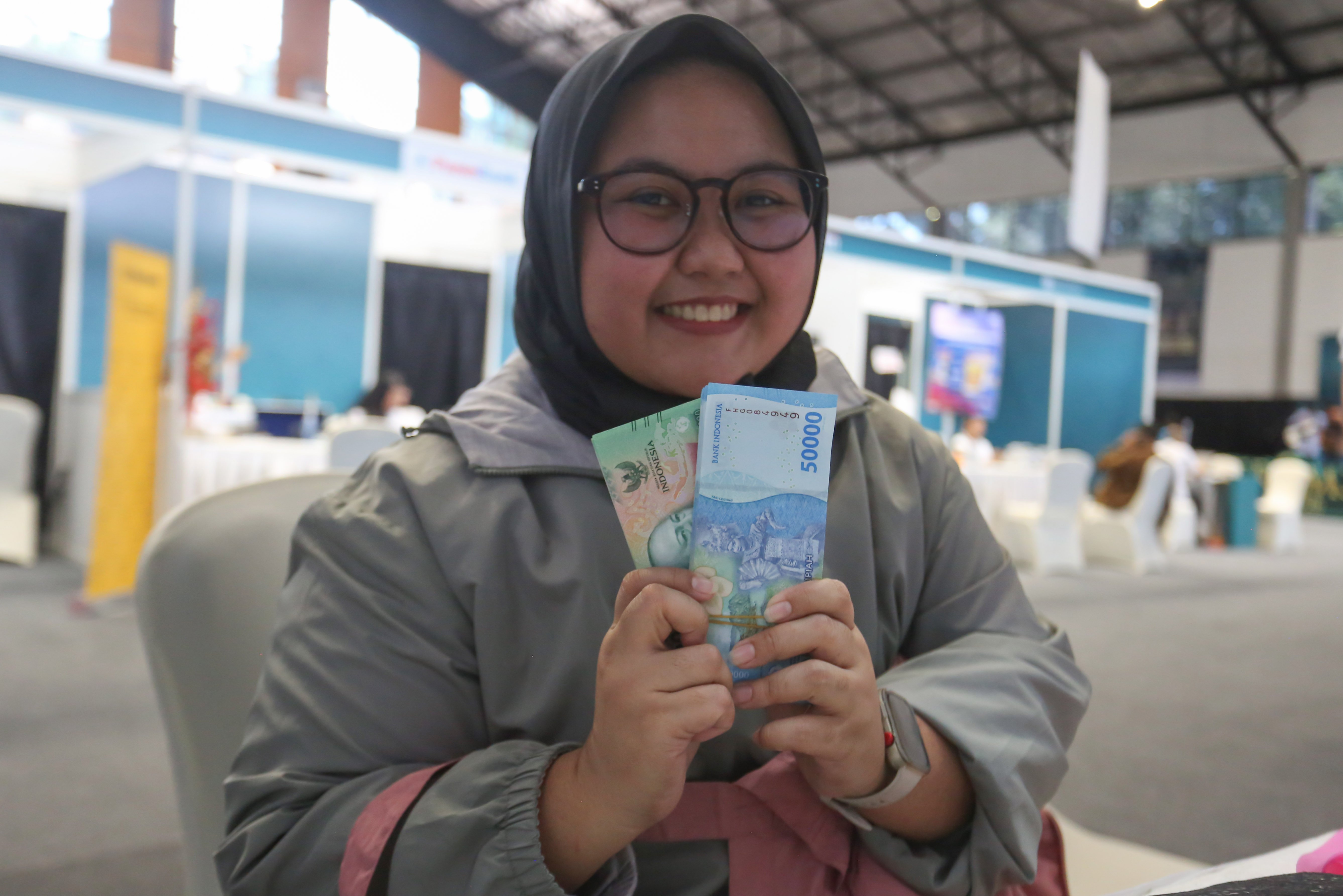 Warga menunjukkan uang baru usai melakukan penukaran pada program Semarak Rupiah Ramadan dan Berkah Idul Fitri (SERAMBI) 2026 di GBK Basket Hall, Jakarta Pusat, Jumat (13/3). Bank Indonesia membuka layanan penukaran uang baru untuk keperluan Hari Raya Idul Fitri 1447 H dengan jumlah tukar maksimal Rp 5,3 juta dan kuota 5.000 orang per harinya yang digelar hingga Minggu, 15 Maret 2026.