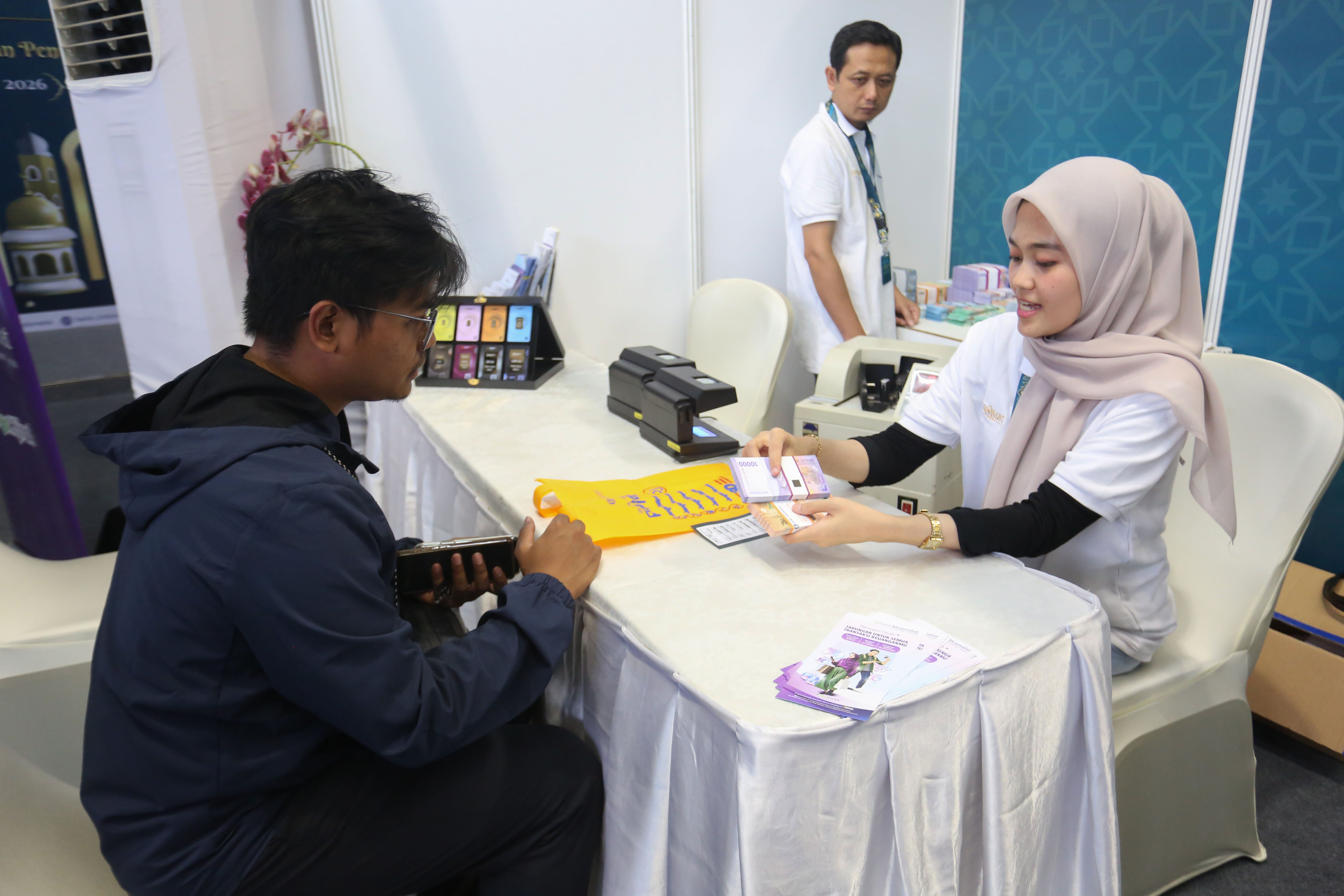 Petugas memberikan uang baru yang ditukarkan warga pada program Semarak Rupiah Ramadan dan Berkah Idul Fitri (SERAMBI) 2026 di GBK Basket Hall, Jakarta Pusat, Jumat (13/3). Bank Indonesia membuka layanan penukaran uang baru untuk keperluan Hari Raya Idul Fitri 1447 H dengan jumlah tukar maksimal Rp 5,3 juta dan kuota 5.000 orang per harinya yang digelar hingga Minggu, 15 Maret 2026.