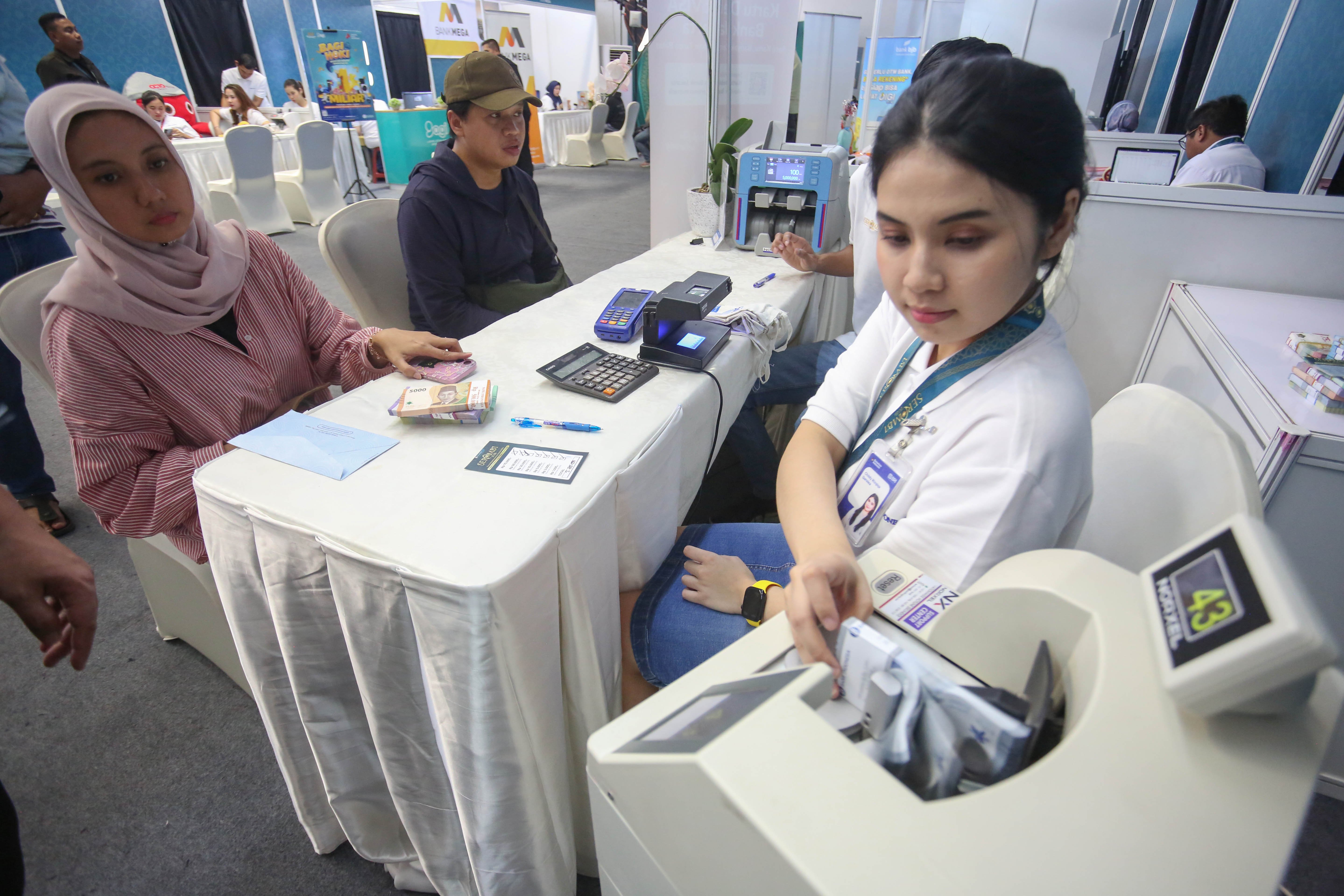 Petugas menghitung uang baru yang ditukarkan warga pada program Semarak Rupiah Ramadan dan Berkah Idul Fitri (SERAMBI) 2026 di GBK Basket Hall, Jakarta Pusat, Jumat (13/3). Bank Indonesia membuka layanan penukaran uang baru untuk keperluan Hari Raya Idul Fitri 1447 H dengan jumlah tukar maksimal Rp 5,3 juta dan kuota 5.000 orang per harinya yang digelar hingga Minggu, 15 Maret 2026.