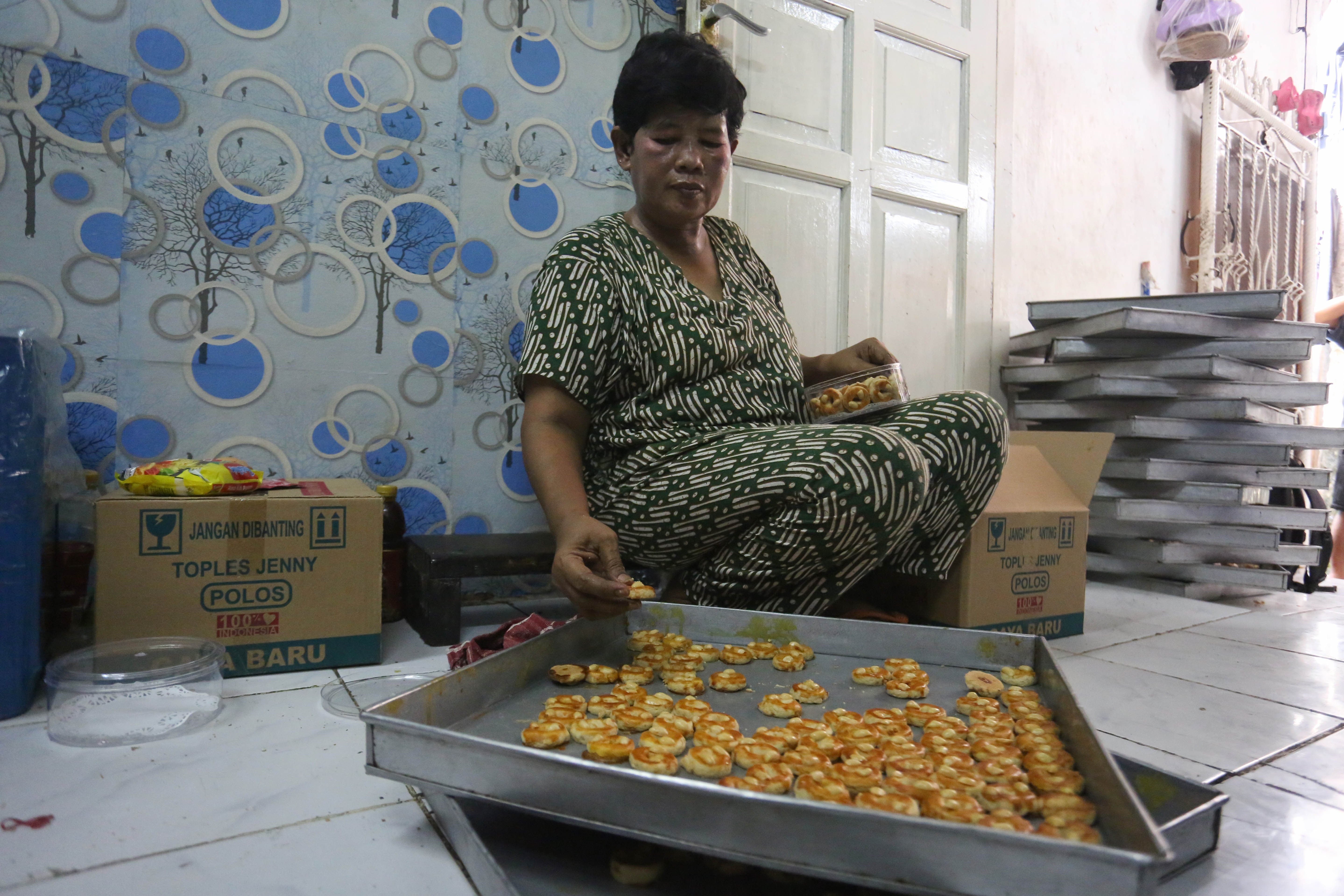 Pekerja menyelesaikan pembuatan kue kering di usaha rumahan Jalan Kembang XI, Kwitang, Senen, Jakarta Pusat, Berdasarkan keterangan Imam (59) selaku pemilik usaha, sepekan menjelang Hari Raya Idul Fitri 1447 H terjadi lonjakan permintaan kue kering dengan mampu memproduksi hingga 30 kaleng per harinya.
