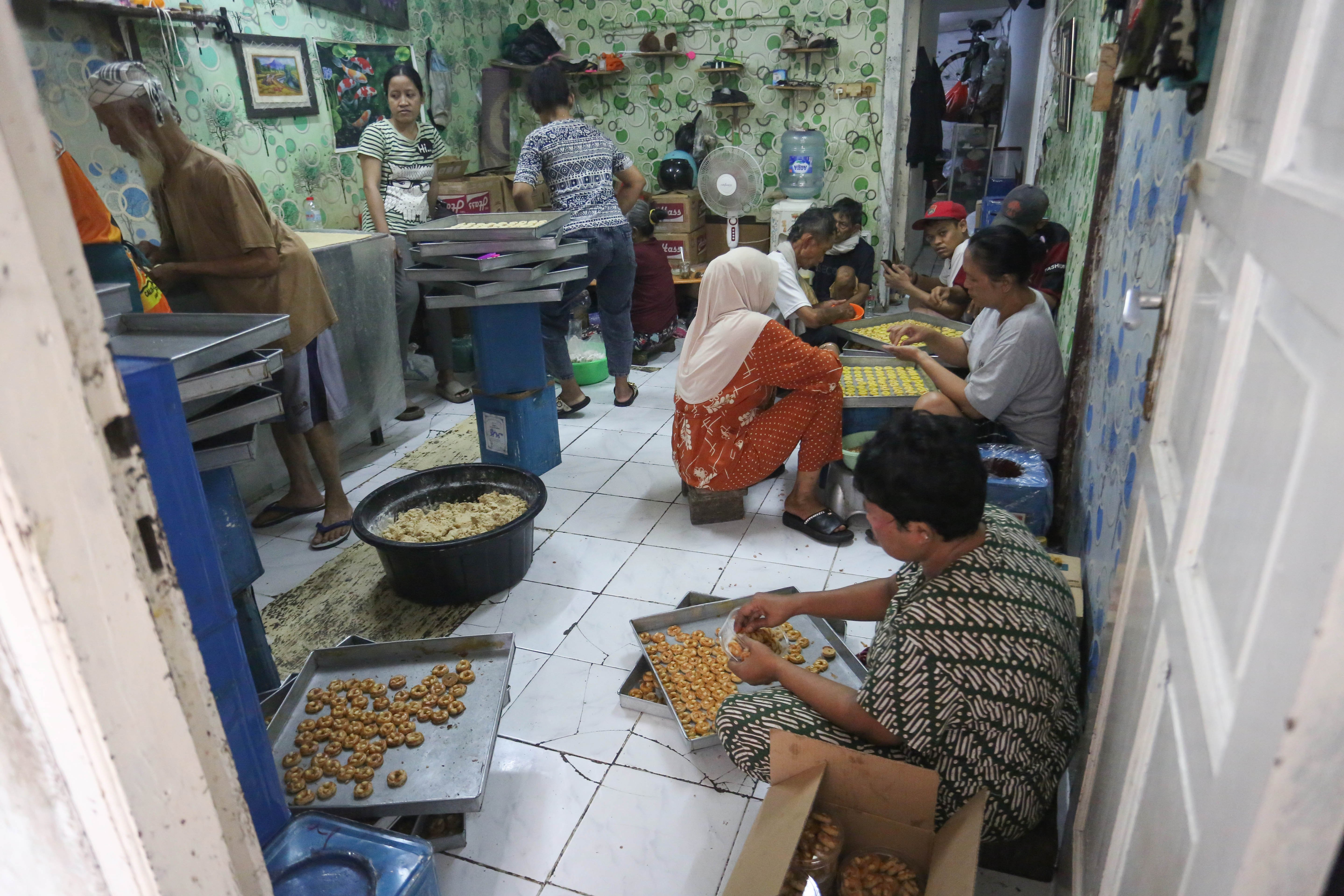 Pekerja menyelesaikan pembuatan kue kering di usaha rumahan Jalan Kembang XI, Kwitang, Senen, Jakarta Pusat, Berdasarkan keterangan Imam (59) selaku pemilik usaha, sepekan menjelang Hari Raya Idul Fitri 1447 H terjadi lonjakan permintaan kue kering dengan mampu memproduksi hingga 30 kaleng per harinya.