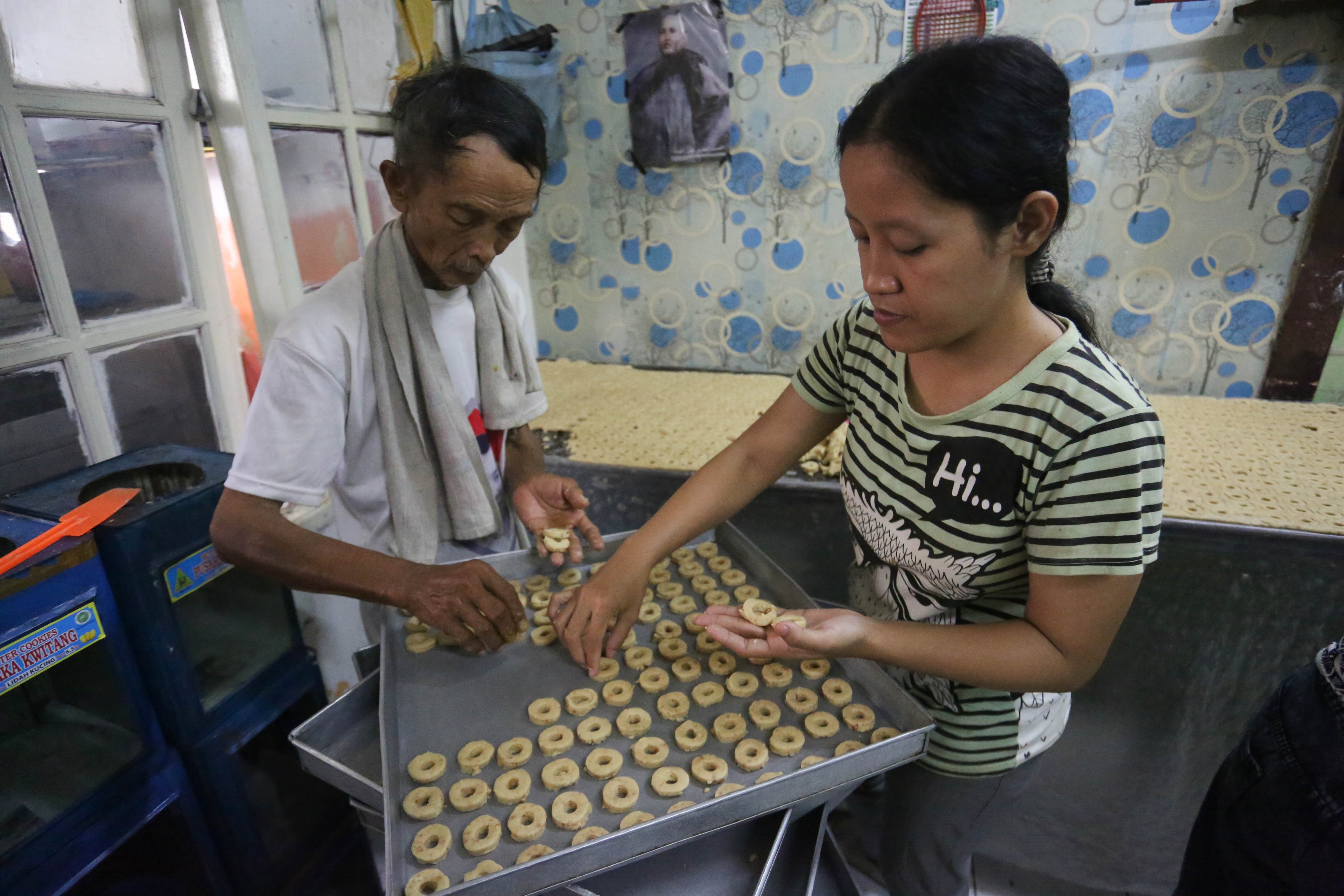 Pekerja menyelesaikan pembuatan kue kering di usaha rumahan Jalan Kembang XI, Kwitang, Senen, Jakarta Pusat, Berdasarkan keterangan Imam (59) selaku pemilik usaha, sepekan menjelang Hari Raya Idul Fitri 1447 H terjadi lonjakan permintaan kue kering dengan mampu memproduksi hingga 30 kaleng per harinya.