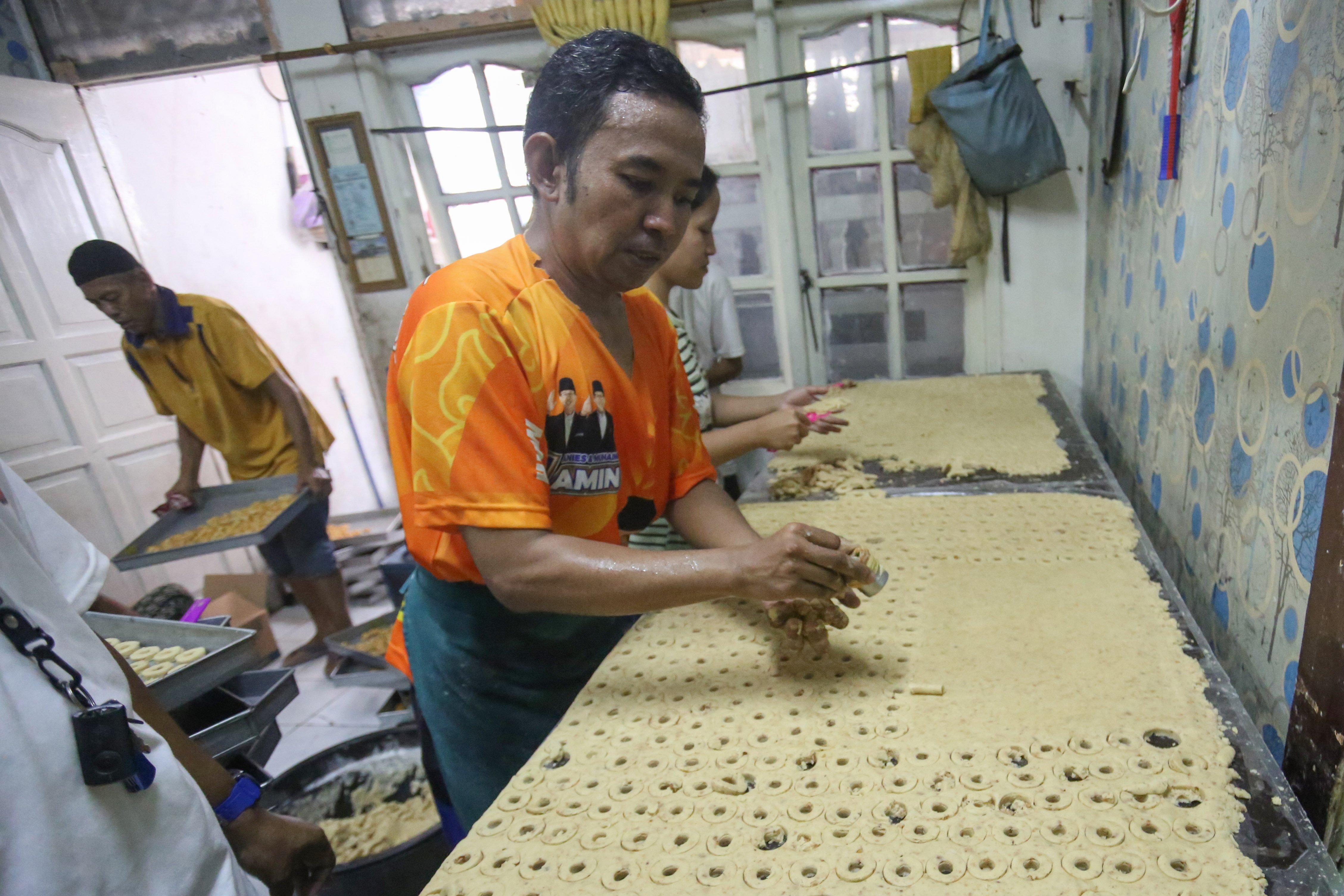 Pekerja menyelesaikan pembuatan kue kering di usaha rumahan Jalan Kembang XI, Kwitang, Senen, Jakarta Pusat, Berdasarkan keterangan Imam (59) selaku pemilik usaha, sepekan menjelang Hari Raya Idul Fitri 1447 H terjadi lonjakan permintaan kue kering dengan mampu memproduksi hingga 30 kaleng per harinya.