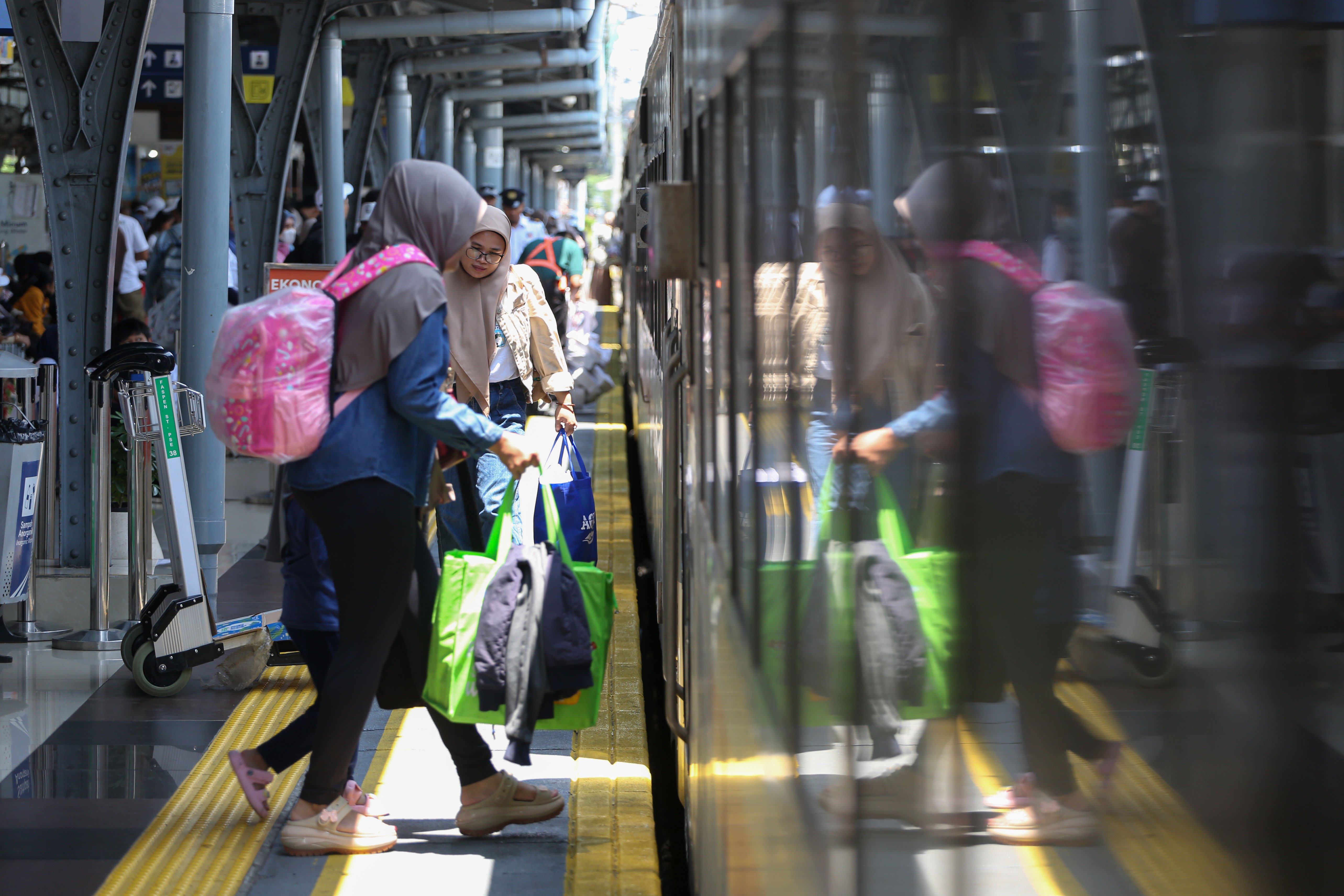 Pemudik berjalan memasuki gerbong kereta api jarak jauh di Stasiun Pasar Senen, Jakarta, Selasa (17/3/2026). Empat hari menjelang Hari Raya Idul Fitri 1447 Hijriah, sebanyak 24.536 pemudik berangkat menggunakan kereta api jarak jauh dari Stasiun Pasar Senen.