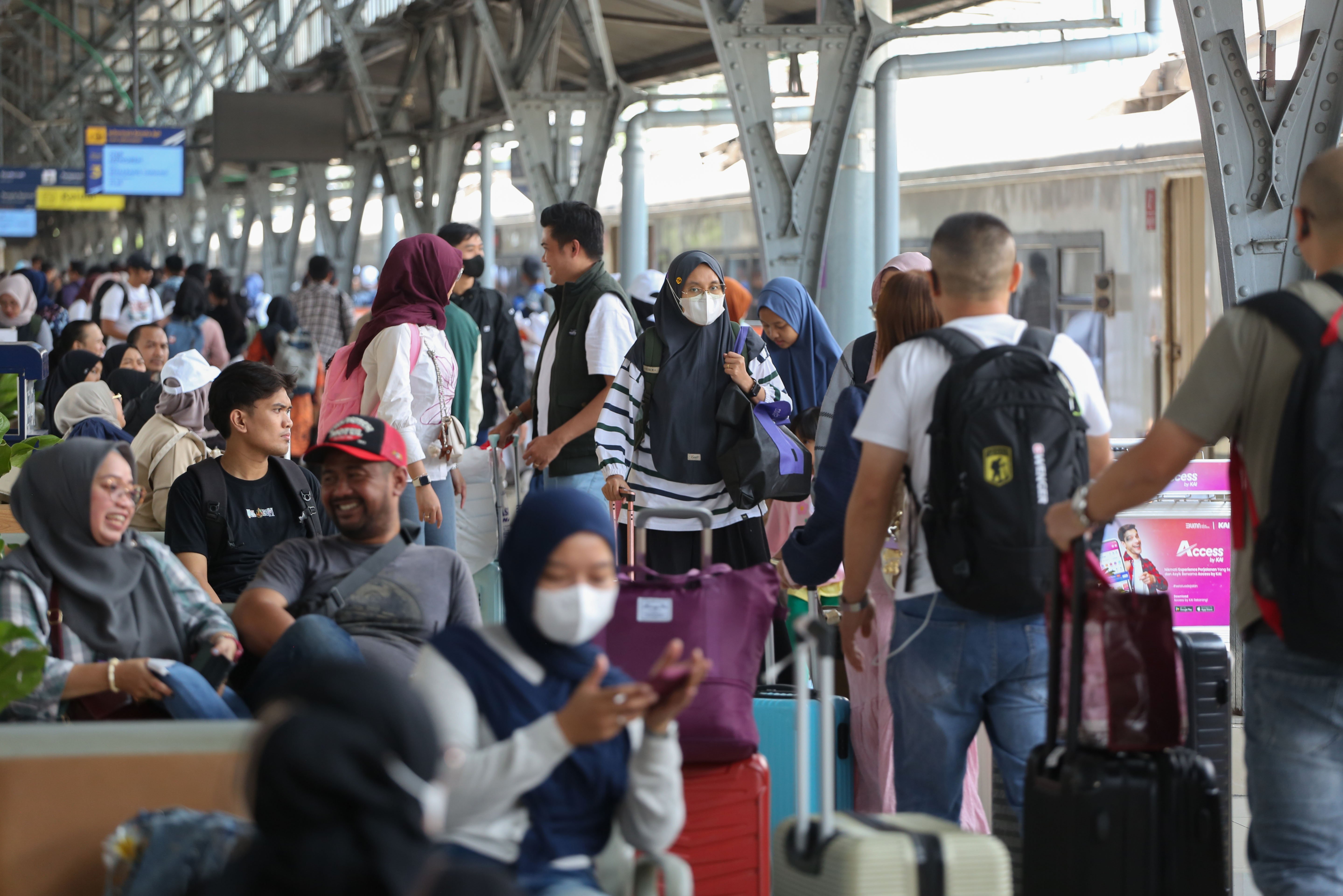 Pemudik berjalan menuju gerbong kereta api jarak jauh di Stasiun Pasar Senen, Jakarta, Selasa (17/3/2026). Empat hari menjelang Hari Raya Idul Fitri 1447 Hijriah, sebanyak 24.536 pemudik berangkat menggunakan kereta api jarak jauh dari Stasiun Pasar Senen.