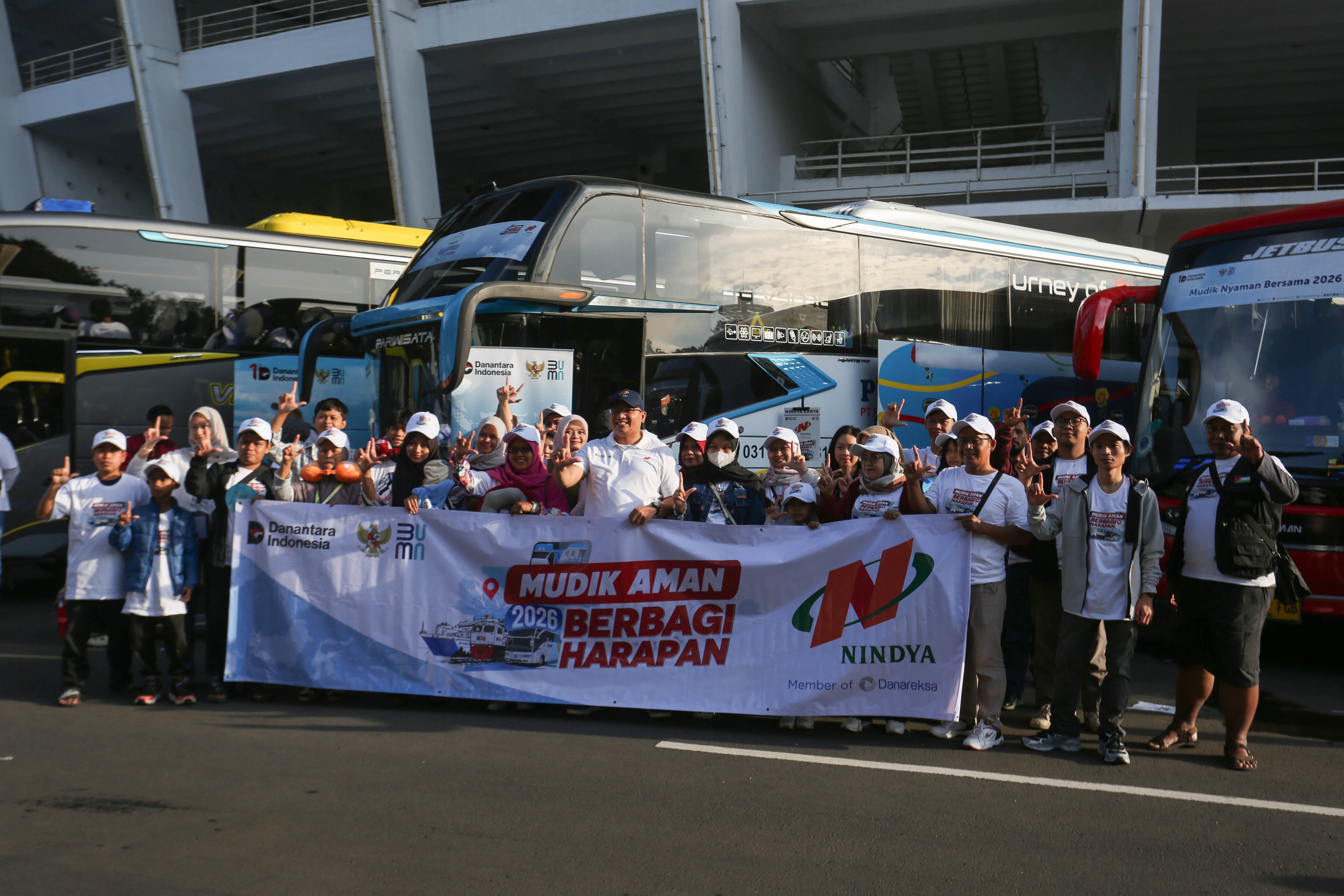 Sejumlah peserta mudik gratis bersama BUMN berfoto bersama di depan bus yang akan diberangkatkan dari Stadion Gelora Bung Karno, Senayan, Jakarta, Selasa (17/3/2026). Sebanyak 116.688 peserta Program Mudik Gratis BUMN 2026 diberangkatkan melalui tiga moda transportasi yakni bus, kereta api dan kapal laut dengan rute tujuan lebih dari 200 kabupaten dan kota di Indonesia.