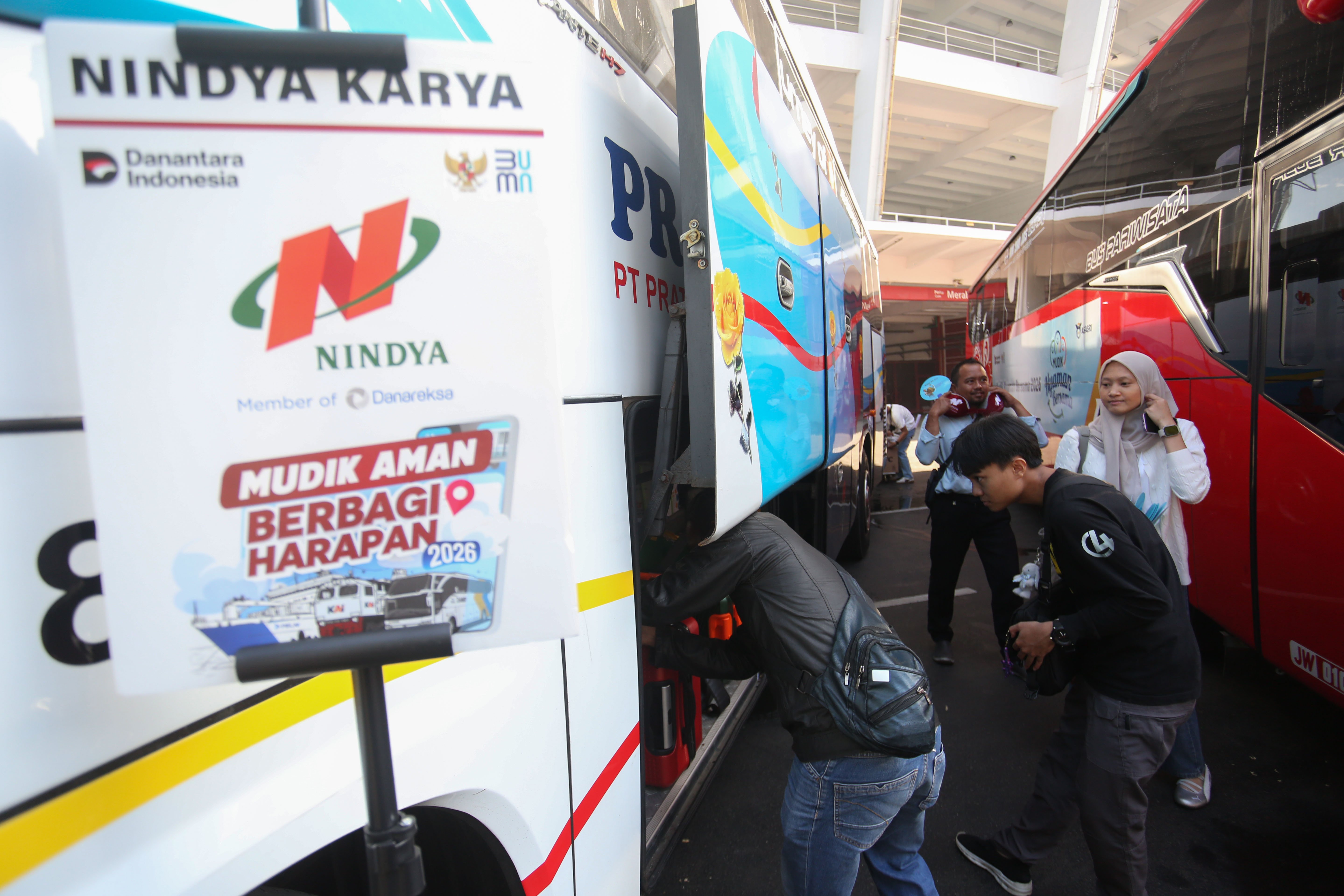 Peserta mudik gratis bersama BUMN memasukkan barang ke dalam bagasi bus yang akan diberangkatkan dari Stadion Gelora Bung Karno, Senayan, Jakarta, Selasa (17/3/2026). Sebanyak 116.688 peserta Program Mudik Gratis BUMN 2026 diberangkatkan melalui tiga moda transportasi yakni bus, kereta api dan kapal laut dengan rute tujuan lebih dari 200 kabupaten dan kota di Indonesia.