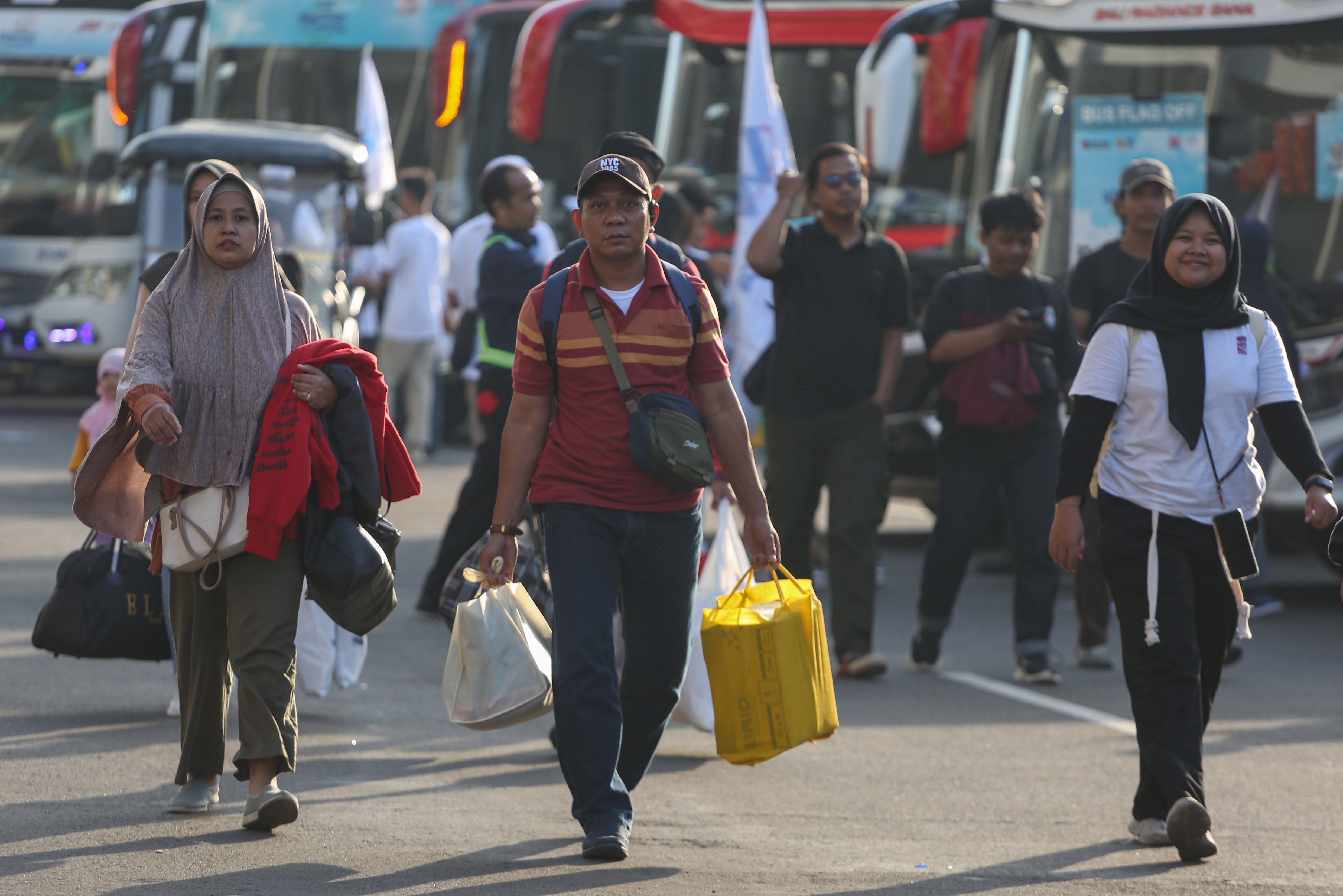 Sejumlah peserta mudik gratis bersama BUMN berjalan menuju bus yang akan diberangkatkan dari Stadion Gelora Bung Karno, Senayan, Jakarta, Selasa (17/3/2026). Sebanyak 116.688 peserta Program Mudik Gratis BUMN 2026 diberangkatkan melalui tiga moda transportasi yakni bus, kereta api dan kapal laut dengan rute tujuan lebih dari 200 kabupaten dan kota di Indonesia.