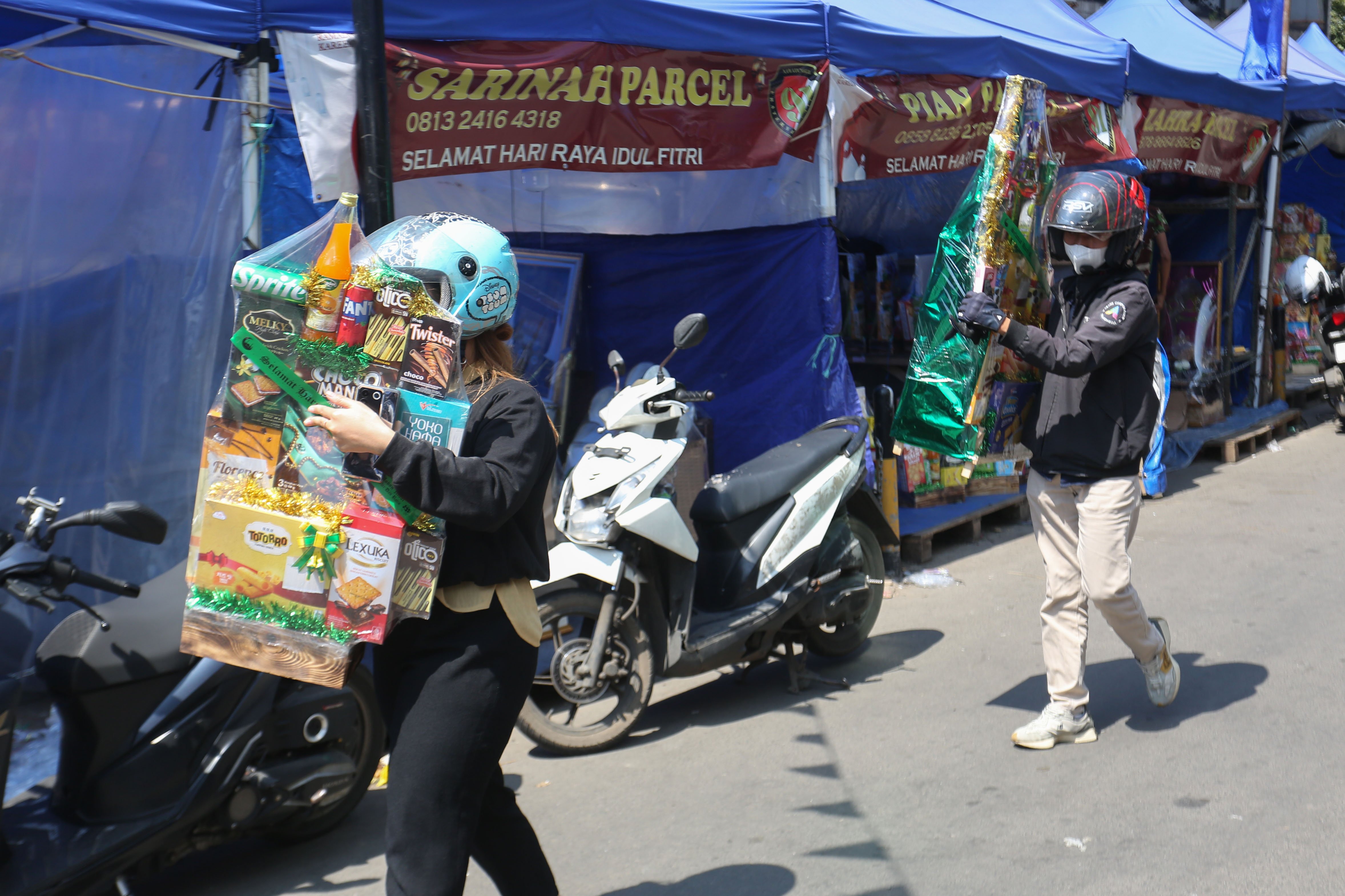 Warga membawa parsel yang telah dibeli di kawasan Pasar Kembang Cikini, Jakarta, Senin (16/3/2026). Berdasarkan penuturan pedagang, pada H-5 Hari Raya Idulfitri 1447 Hijriah penjualan parsel seharga Rp 150 ribu hingga Rp 1,5 juta per paket tersebut meningkat hingga dua kali lipat.