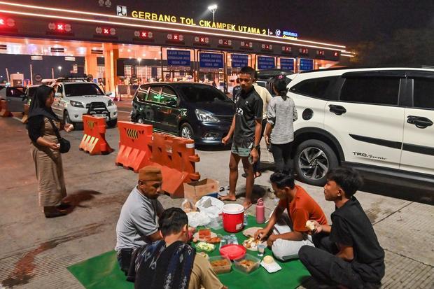 Pemudik berhenti dibahu jalan untuk menyantap makanan untuk sahur di Gerbang Tol Cikampek Utama, Jawa Barat, Rabu (18/3/2026). Sejumlah pemudik sahur dan istirahat di bahu jalan tol karena tidak memungkinkan menuju rest area terdekat karena imbas kepadatan lalu lintas pada H-3 Lebaran Idul Fitri 2026.