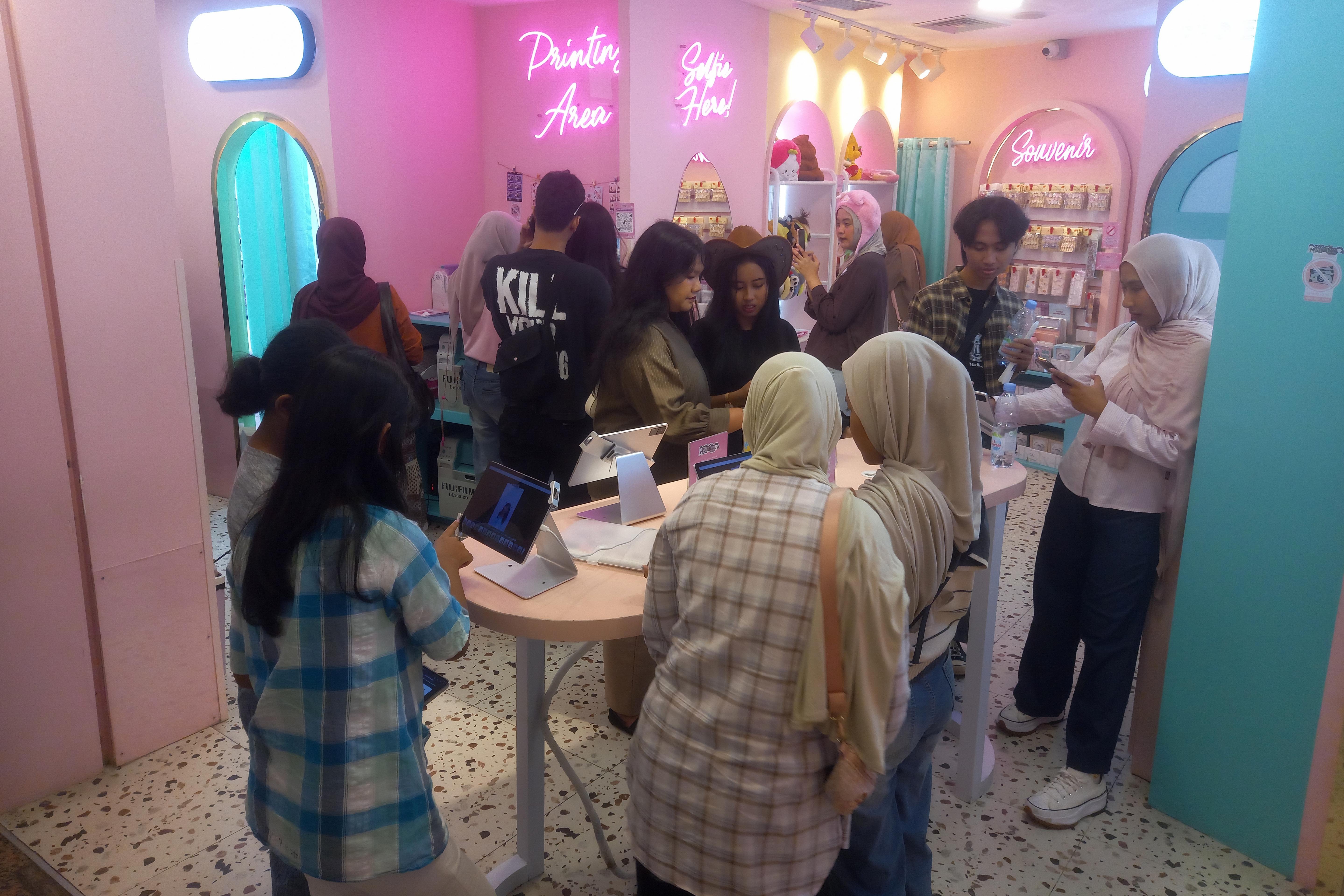 Pengunjung melihat jasa foto yang ditawarkan pada salah satu gerai di Mal Plaza Blok M, Jakarta Selatan, Rabu (25/3/2026). Asosiasi Pengelola Pusat Belanja Indonesia (APPBI) melaporkan kunjungan masyarakat ke pusat perbelanjaan atau mal pada periode Idulfitri 2026 meningkat hingga 12% dibandingkan tahun sebelumnya.