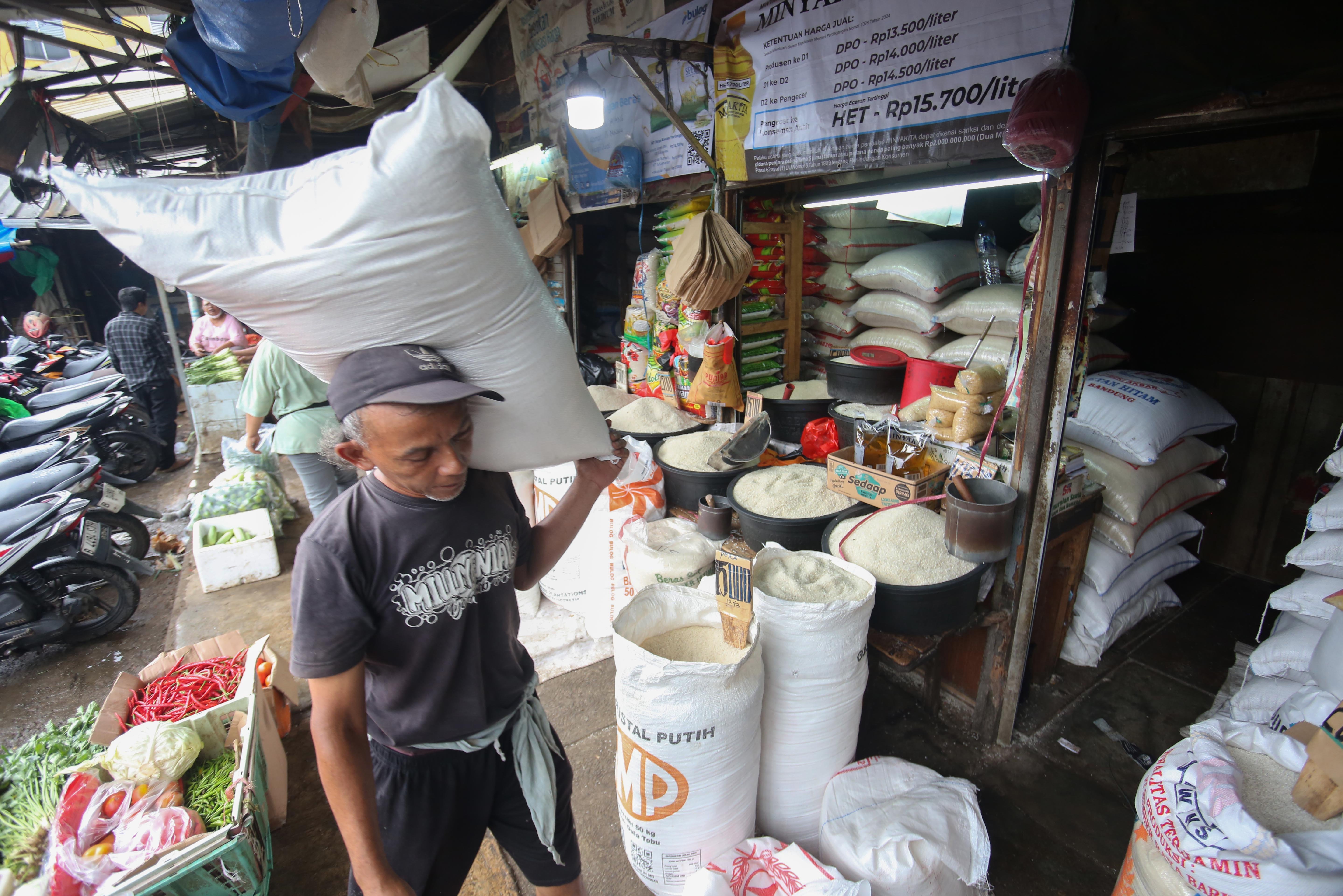 Pekerja mengangkut beras yang akan dijual kepada pembeli di Pasar Minggu, Jakarta Selatan, Kamis (26/3/2026). Lima hari setelah Lebaran, harga beras premium belum mengalami penurunan yakni masih berada di angka Rp 14.500 per liter