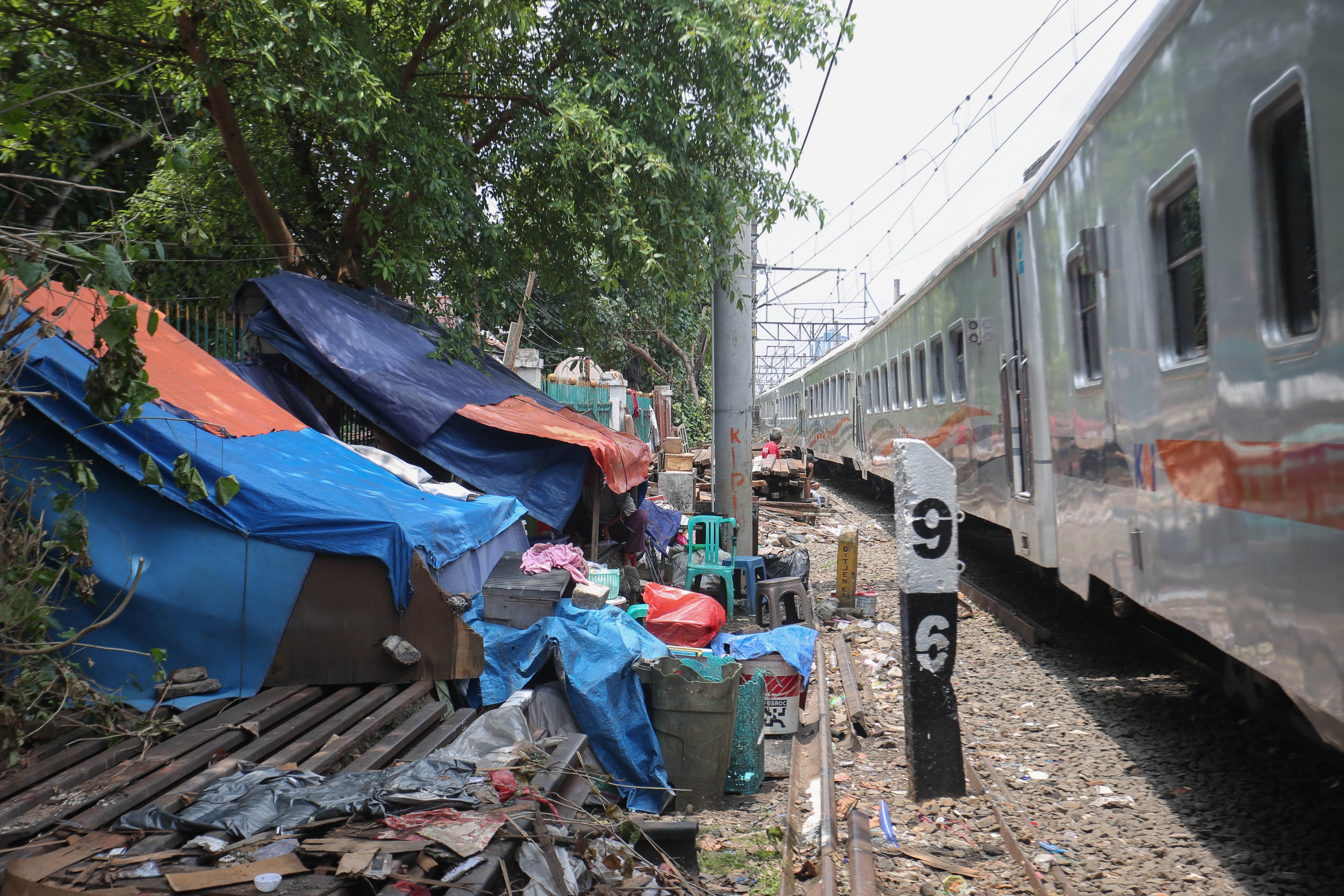 Kereta api melintas di dekat tempat tinggal warga yang berada di di bantaran rel, kawasan Senen, Jakarta Pusat, Senin (30/3/2026). Presiden Prabowo Subianto menyatakan bahwa akan membangun hunian layak bagi warga yang tinggal di pinggir rel kawasan tersebut.