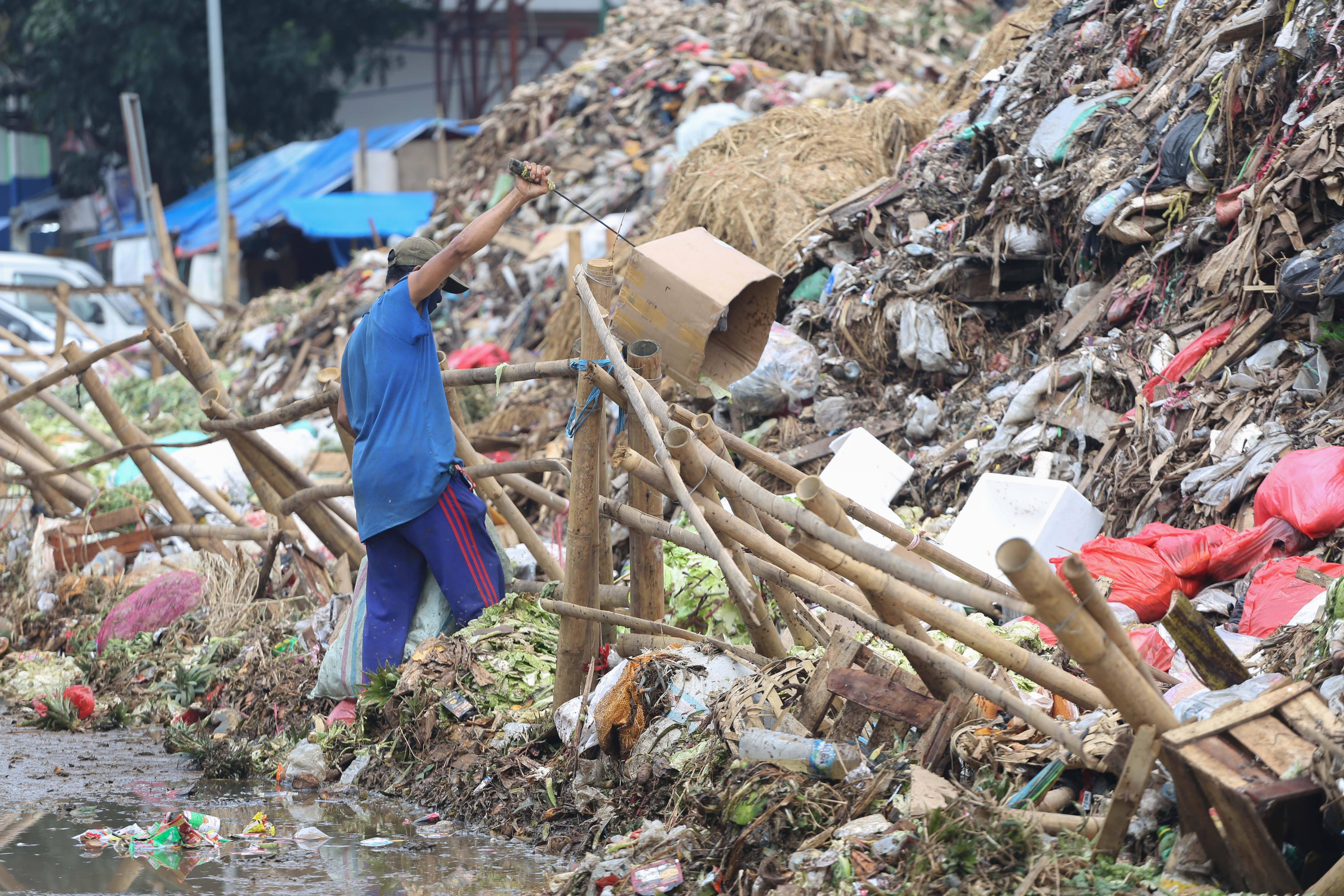 Pemulung memungut kardus dari tumpukan sampah di Pasar Induk Kramat Jati, Jakarta Timur, Rabu (1/4/2026). Keterbatasan kuota pembuangan ke Tempat Pengolahan Sampah Terpadu (TPST) Bantar Gebang pascainsiden longsor yang terjadi membuat sampah menumpuk di Pasar Induk Kramat Jati.