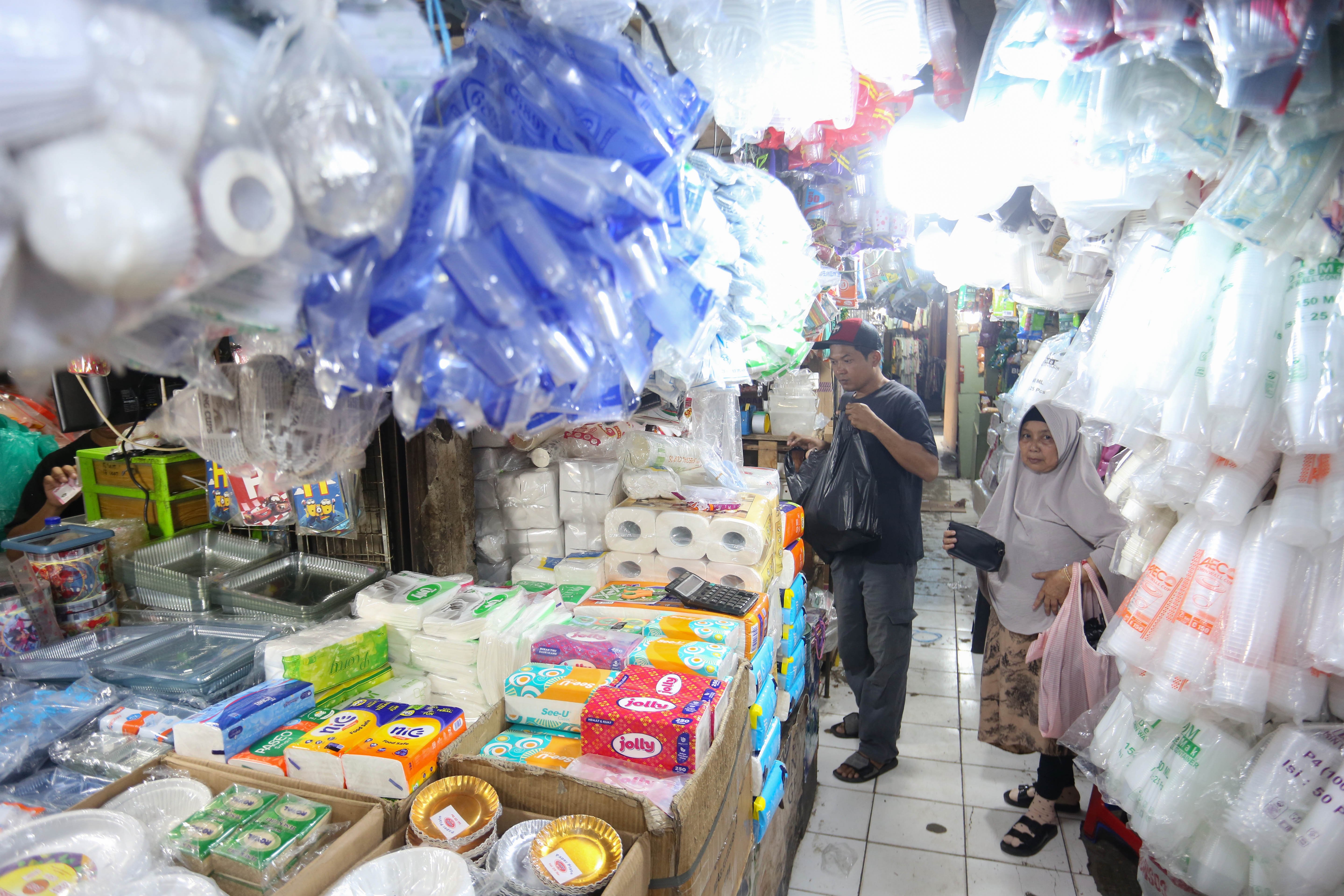 Calon pembeli melihat plastik yang dijual di Pasar Minggu, Jakarta, Kamis (2/4/2026). Kemasan plastik mengalami kenaikan harga dari Rp 6 ribu-Rp 25 ribu menjadi Rp 14 ribu-Rp 35 ribu per kemasan akibat melonjaknya harga bahan baku bijih plastik yakni nafta imbas dari perang di Timur Tengah antara Iran dan Amerika Serikat-Israel.