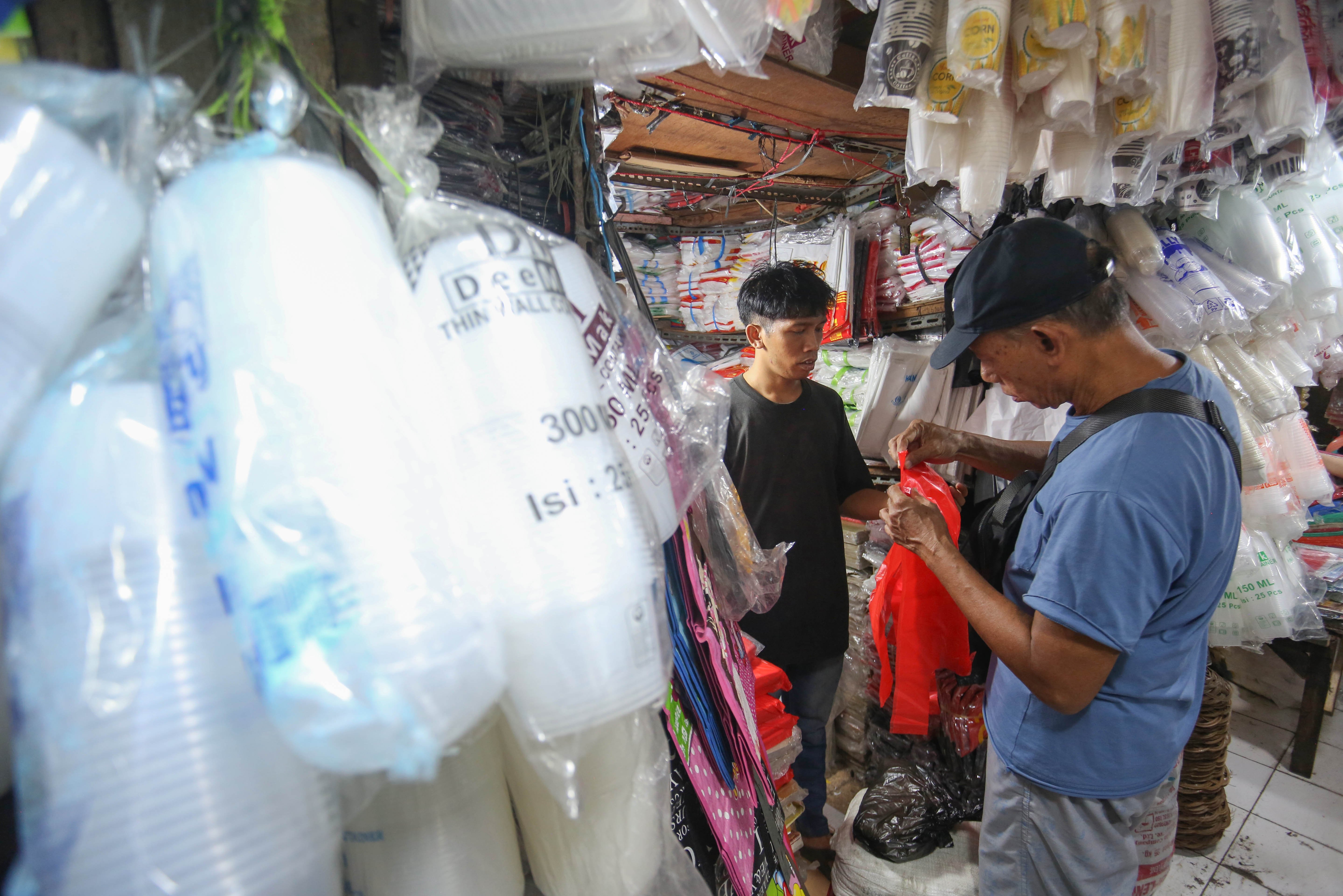 Calon pembeli melihat plastik yang dijual di Pasar Minggu, Jakarta, Kamis (2/4/2026). Kemasan plastik mengalami kenaikan harga dari Rp 6 ribu-Rp 25 ribu menjadi Rp 14 ribu-Rp 35 ribu per kemasan akibat melonjaknya harga bahan baku bijih plastik yakni nafta imbas dari perang di Timur Tengah antara Iran dan Amerika Serikat-Israel.