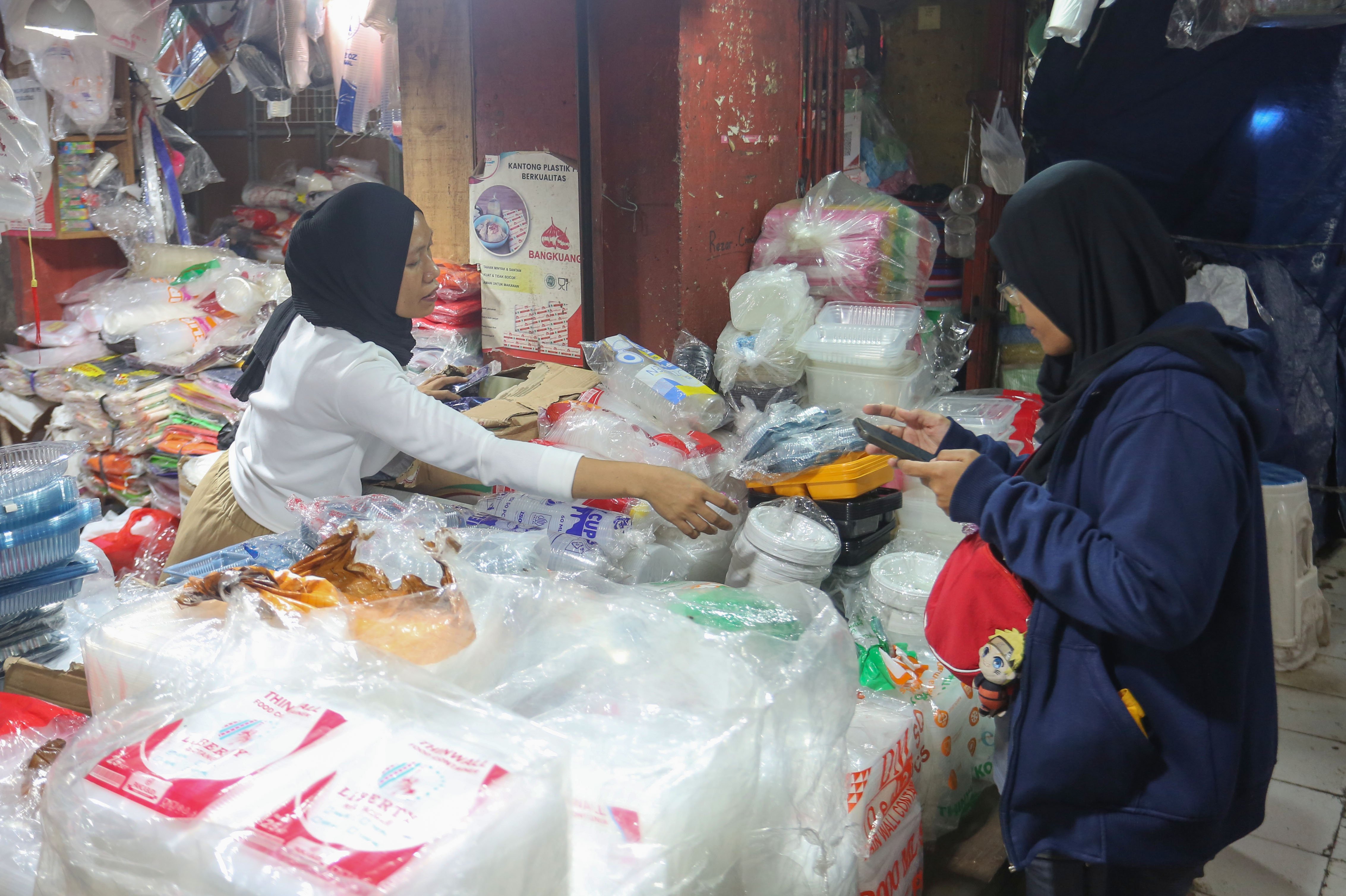 Pedagang melayani calon pembeli yang hendak membeli plastik di Pasar Minggu, Jakarta, Kamis (2/4/2026). Kemasan plastik mengalami kenaikan harga dari Rp 6 ribu-Rp 25 ribu menjadi Rp 14 ribu-Rp 35 ribu per kemasan akibat melonjaknya harga bahan baku bijih plastik yakni nafta imbas dari perang di Timur Tengah antara Iran dan Amerika Serikat-Israel.