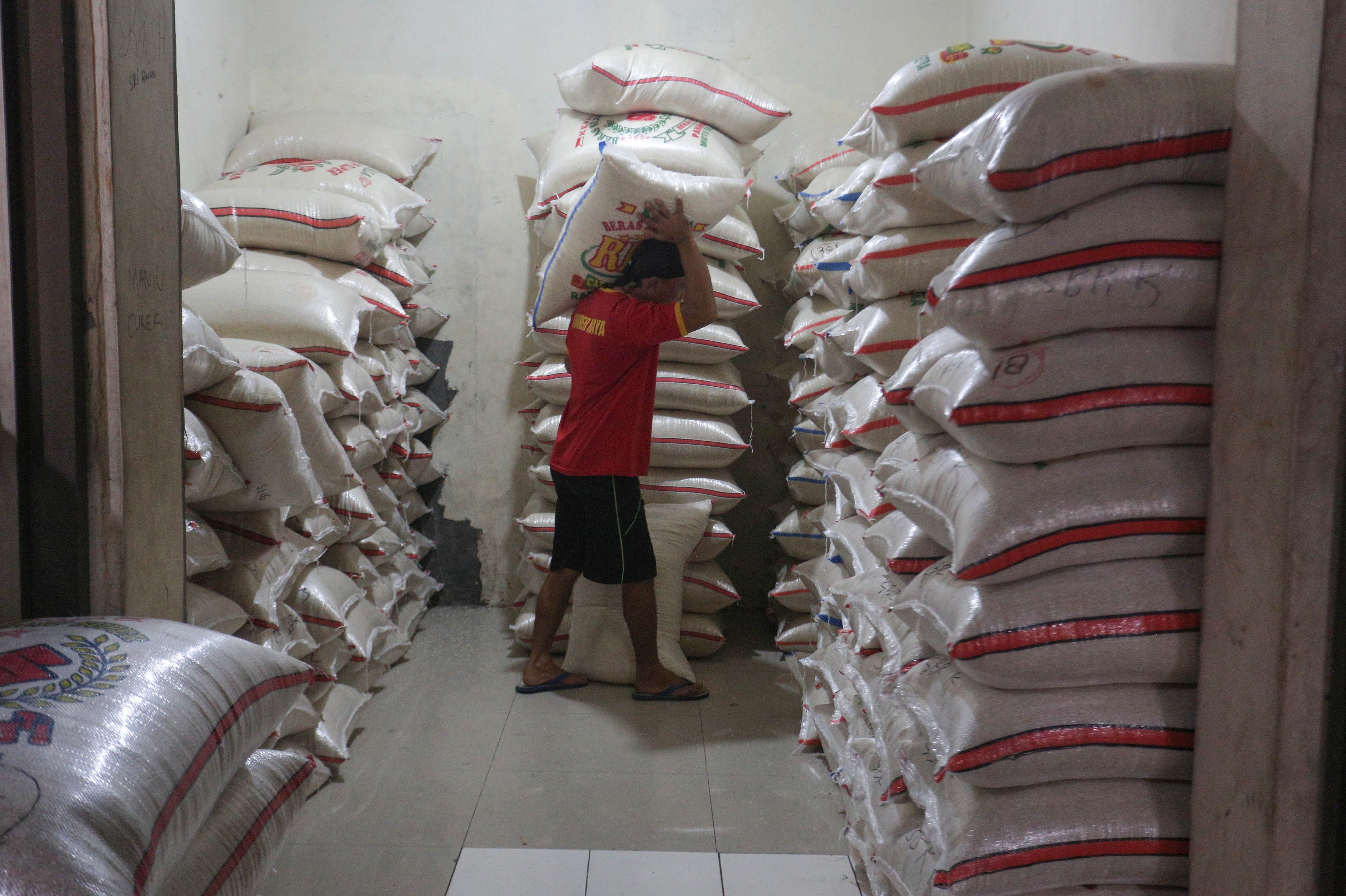 Pekerja mengangkut karung berisi beras di Toko Beras Sumber Raya Pejaten, Pasar Minggu, Jakarta Selatan, Selasa (7/4/2026). Menteri Pertanian sekaligus Kepala Badan Pangan Nasional (Bapanas), Andi Amran Sulaiman, menyebut bahwa stok beras nasional aman untuk memenuhi kebutuhan selama 10–11 bulan ke depan di tengah meningkatnya ancaman krisis pangan global.