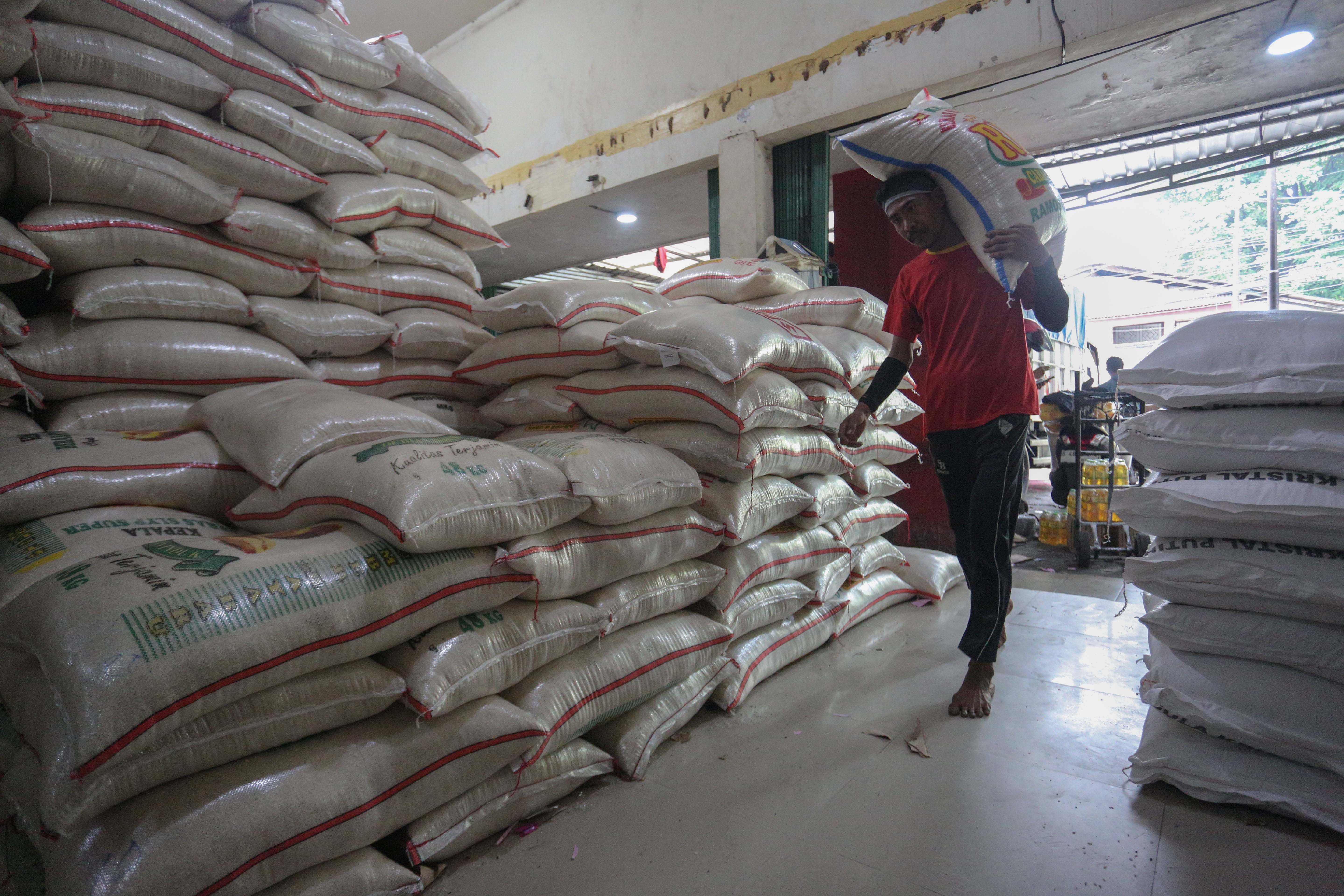 Pekerja mengangkut karung berisi beras di Toko Beras Sumber Raya Pejaten, Pasar Minggu, Jakarta Selatan, Selasa (7/4/2026). Menteri Pertanian sekaligus Kepala Badan Pangan Nasional (Bapanas), Andi Amran Sulaiman, menyebut bahwa stok beras nasional aman untuk memenuhi kebutuhan selama 10–11 bulan ke depan di tengah meningkatnya ancaman krisis pangan global.