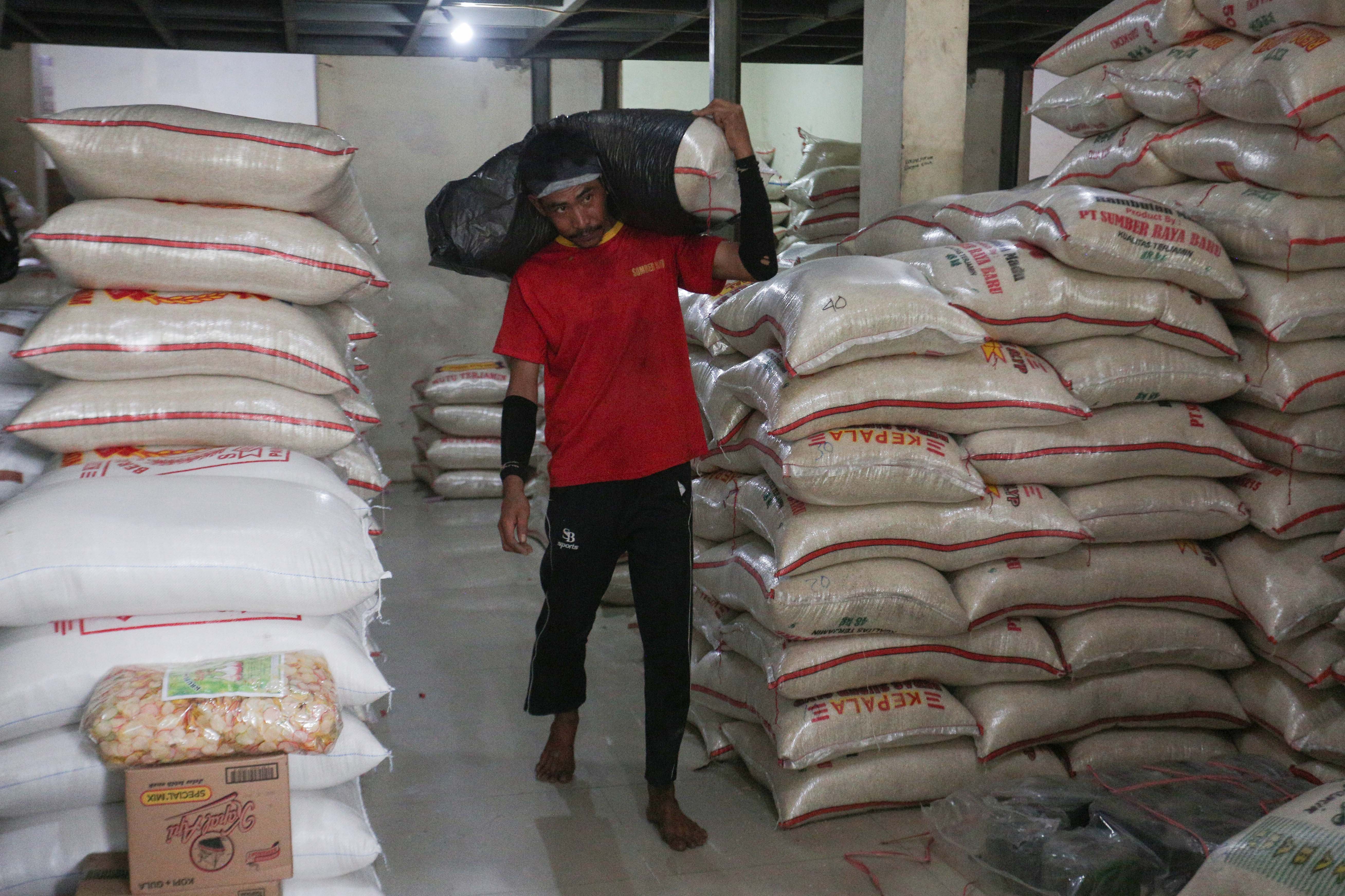Pekerja mengangkut karung berisi beras di Toko Beras Sumber Raya Pejaten, Pasar Minggu, Jakarta Selatan, Selasa (7/4/2026). Menteri Pertanian sekaligus Kepala Badan Pangan Nasional (Bapanas), Andi Amran Sulaiman, menyebut bahwa stok beras nasional aman untuk memenuhi kebutuhan selama 10–11 bulan ke depan di tengah meningkatnya ancaman krisis pangan global.