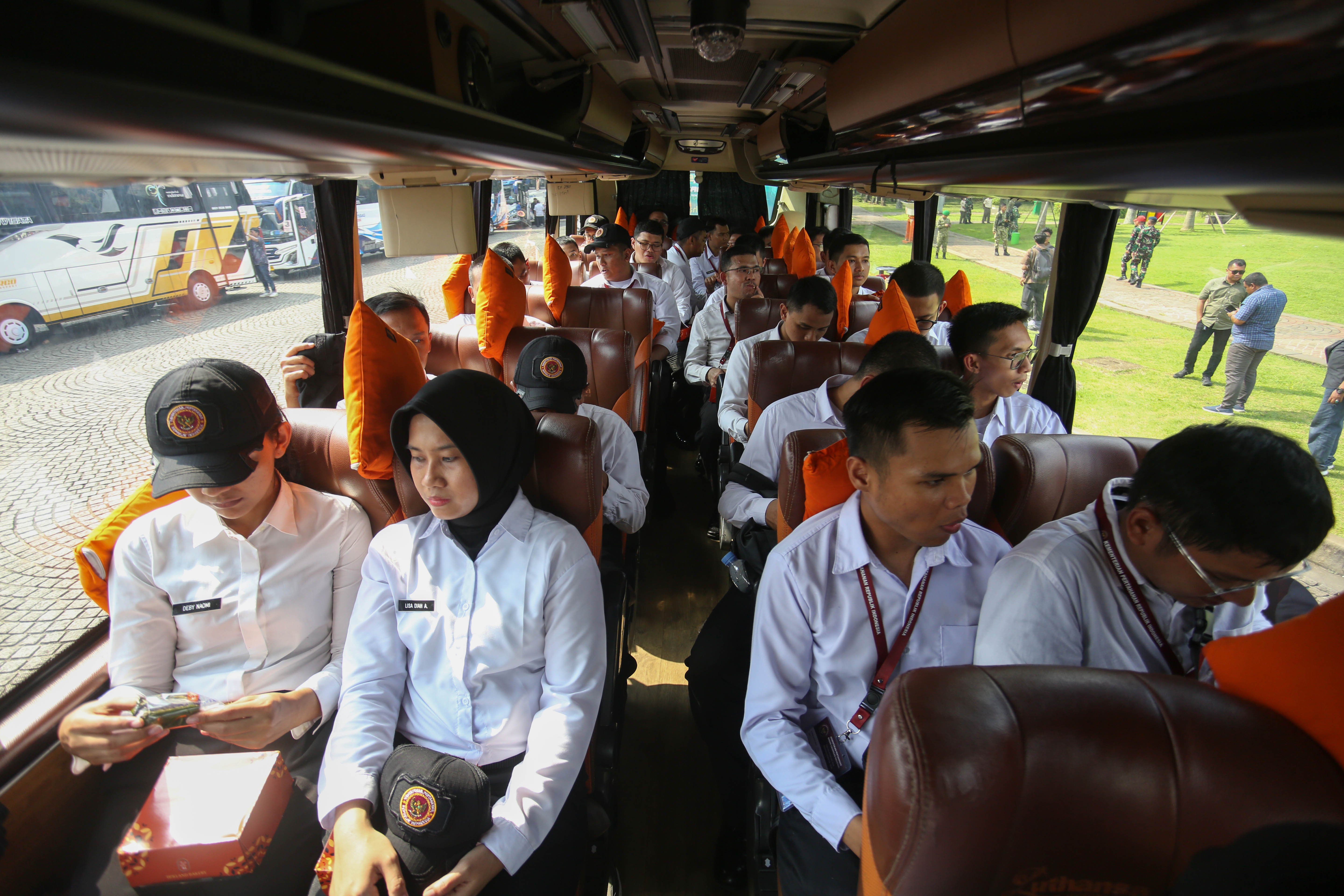 Sejumlah Aparatur Sipil Negara (ASN) berada di dalam bus yang akan diberangkatkan ke Lembaga Pendidikan TNI pada program Komponen Cadangan (Komcad) ASN di Lapangan Monas, Jakarta, Senin (13/4/2026). Kemhan melepas 2.000 ASN dari Kementerian dan Lembaga untuk menjalani pelatihan dasar militer selama 1,5 bulan dalam program Komcad yang bertujuan untuk menumbuhkan nasionalisme serta meningkatkan kedisiplinan dalam memberikan pelayanan ke publik.