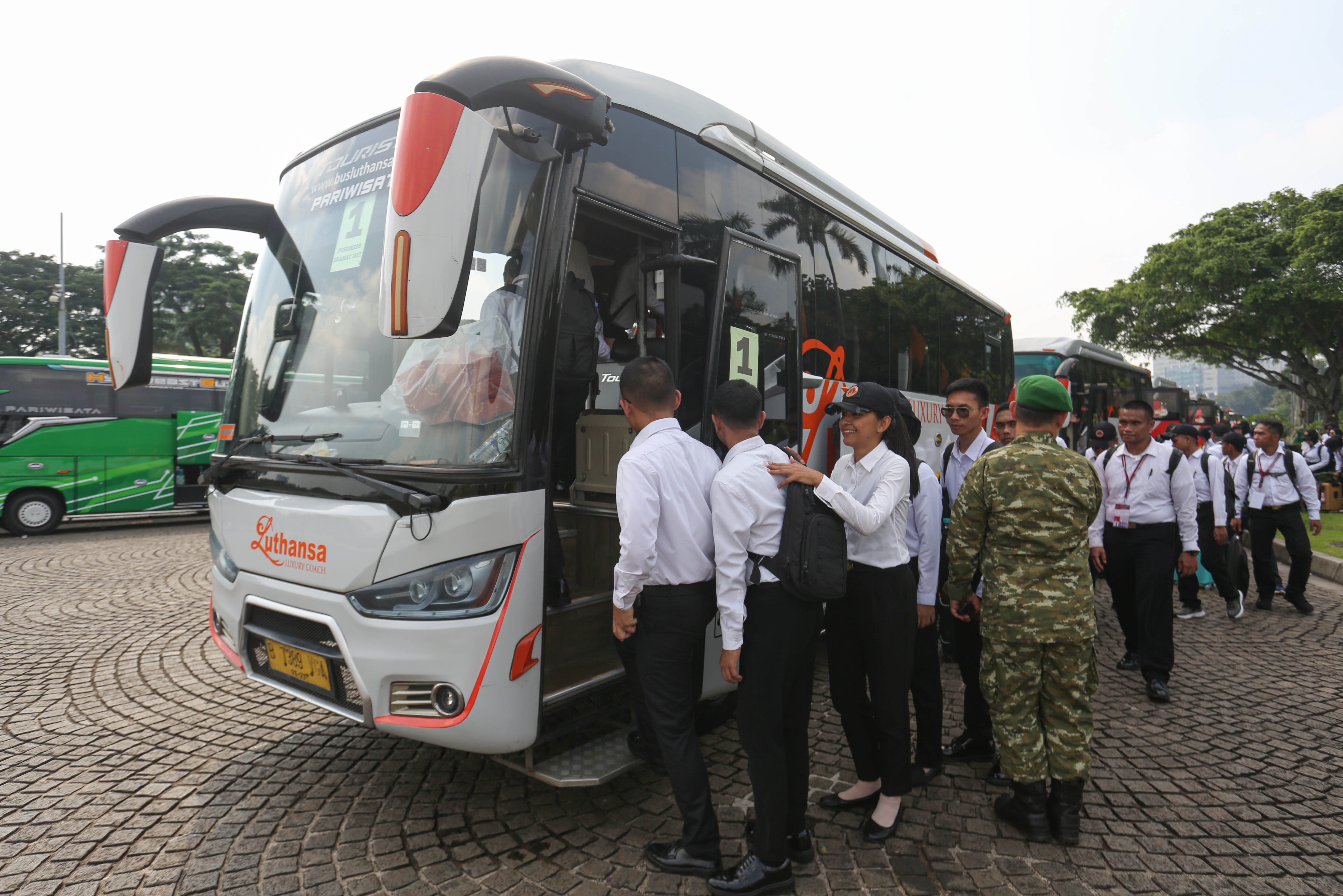 Sejumlah Aparatur Sipil Negara (ASN) berjalan menuju bus yang akan diberangkatkan ke Lembaga Pendidikan TNI pada program Komponen Cadangan (Komcad) ASN di Lapangan Monas, Jakarta, Senin (13/4/2026). Kemhan melepas 2.000 ASN dari Kementerian dan Lembaga untuk menjalani pelatihan dasar militer selama 1,5 bulan dalam program Komcad yang bertujuan untuk menumbuhkan nasionalisme serta meningkatkan kedisiplinan dalam memberikan pelayanan ke publik.