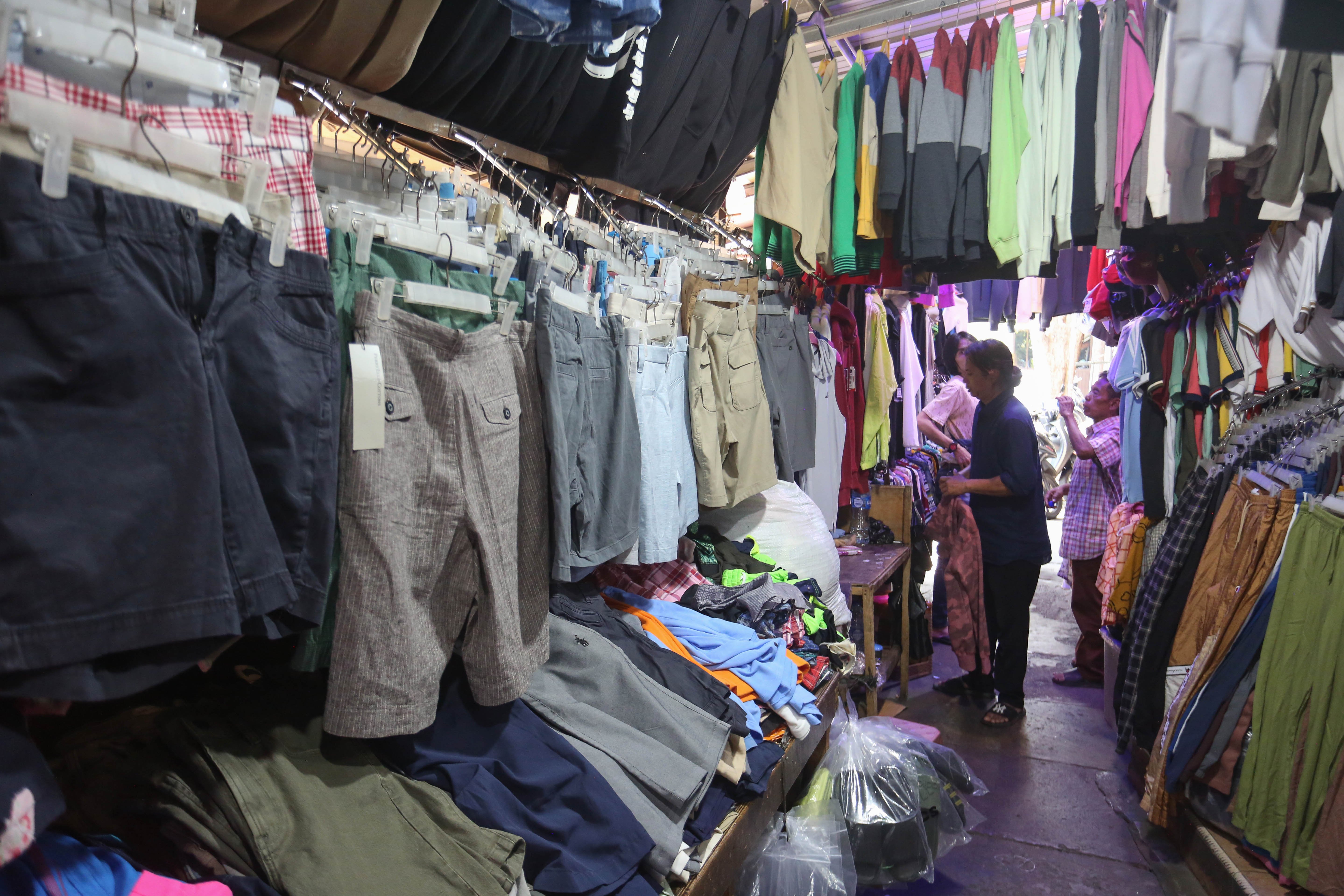 Pedagang merapikan pakaian yang dijual di Pasar Ular, Koja, Jakarta Utara, Jumat (17/4/2026). Berdasarkan penuturan pedagang, sejak pandemi Covid-19 dan munculnya platform belanja online membuat penjualan barang dagangan di pasar tersebut menurun hingga 50 persen.