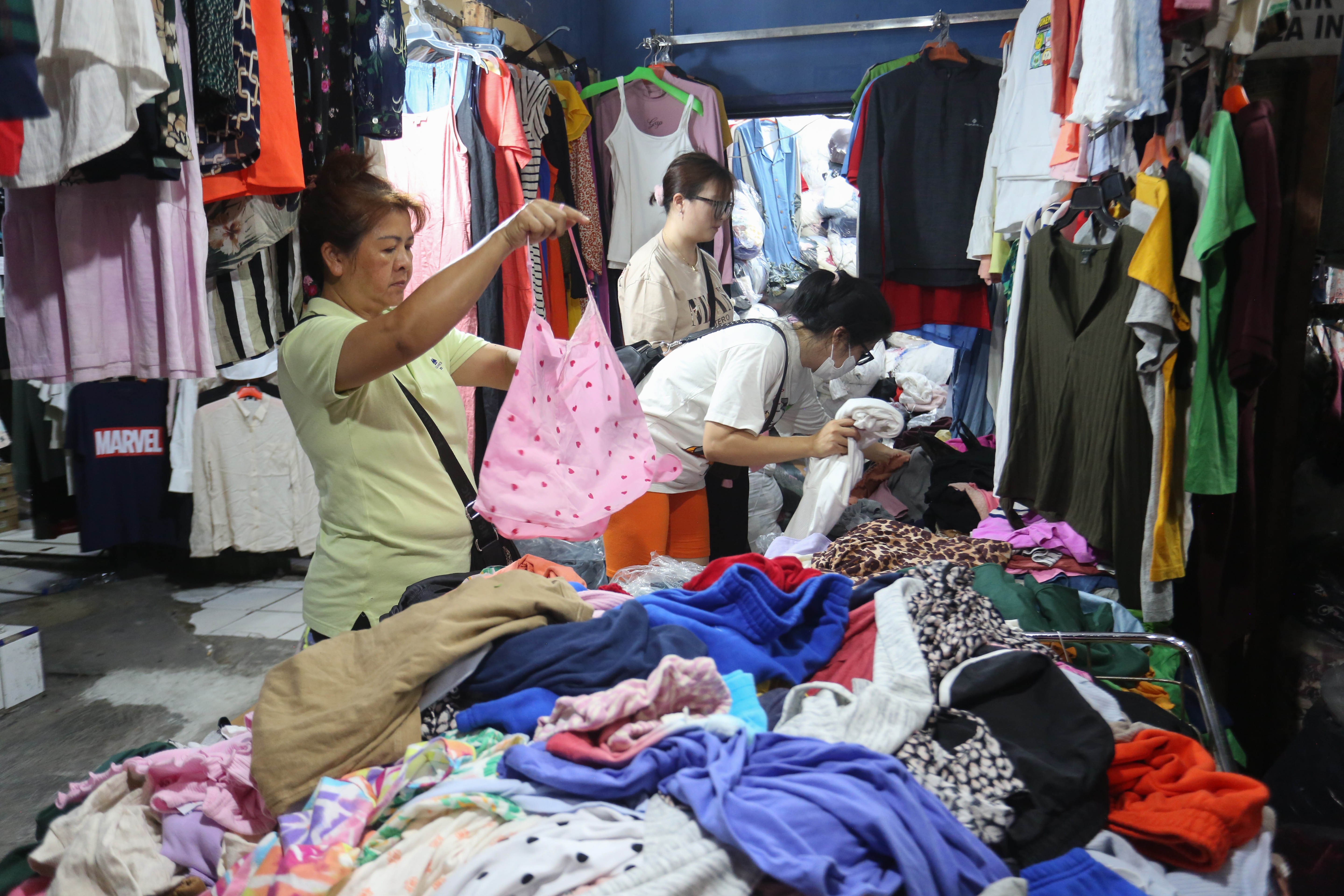 Calon pembeli melihat pakaian yang dijual di kiosnya, Pasar Ular, Koja, Jakarta Utara, Jumat (17/4/2026). Berdasarkan penuturan pedagang, sejak pandemi Covid-19 dan munculnya platform belanja online membuat penjualan barang dagangan di pasar tersebut menurun hingga 50 persen.