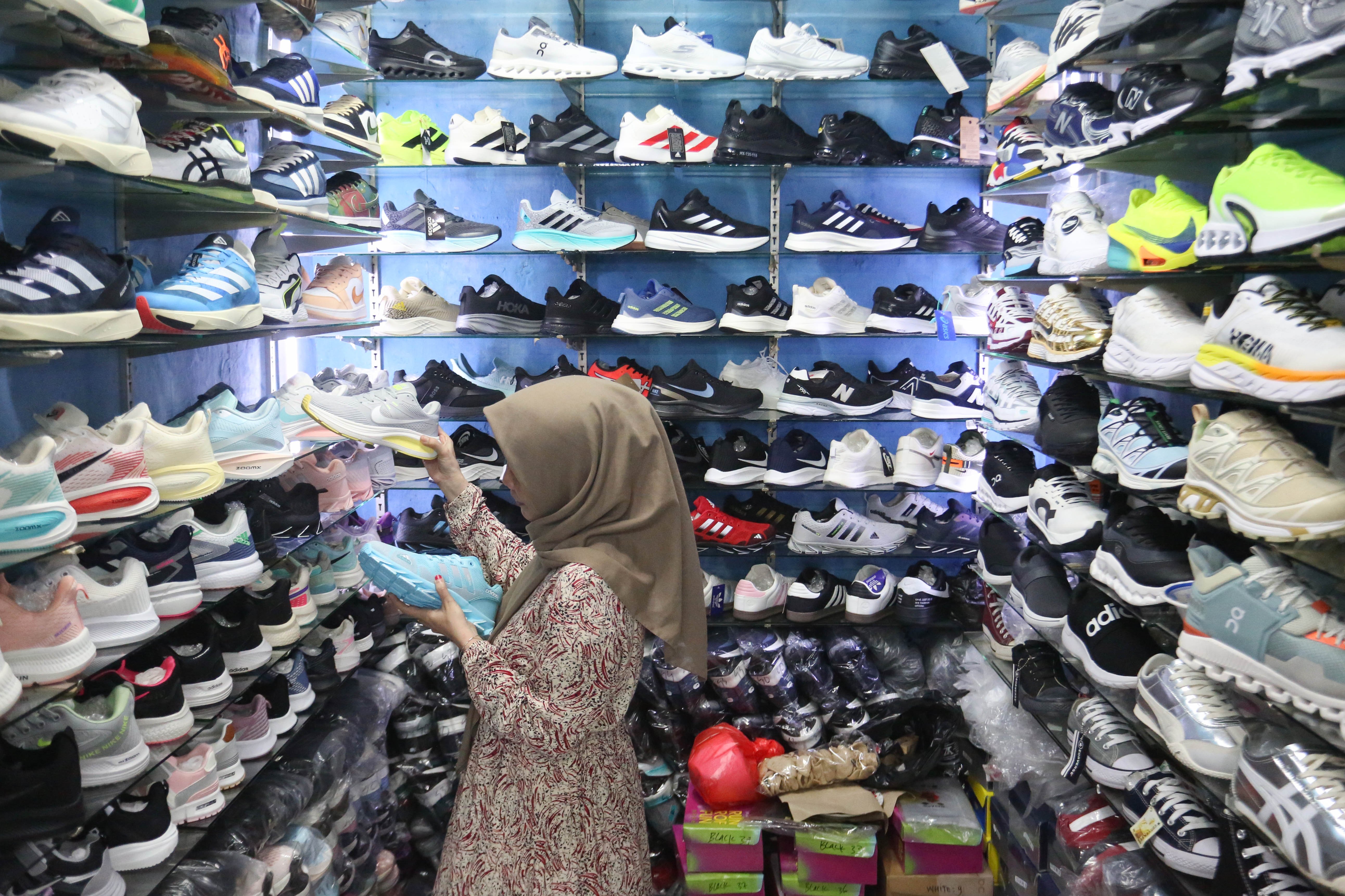 Calon pembeli melihat sepatu yang dijual di Pasar Ular, Koja, Jakarta Utara, Jumat (17/4/2026). Berdasarkan penuturan pedagang, sejak pandemi Covid-19 dan munculnya platform belanja online membuat penjualan barang dagangan di pasar tersebut menurun hingga 50 persen.