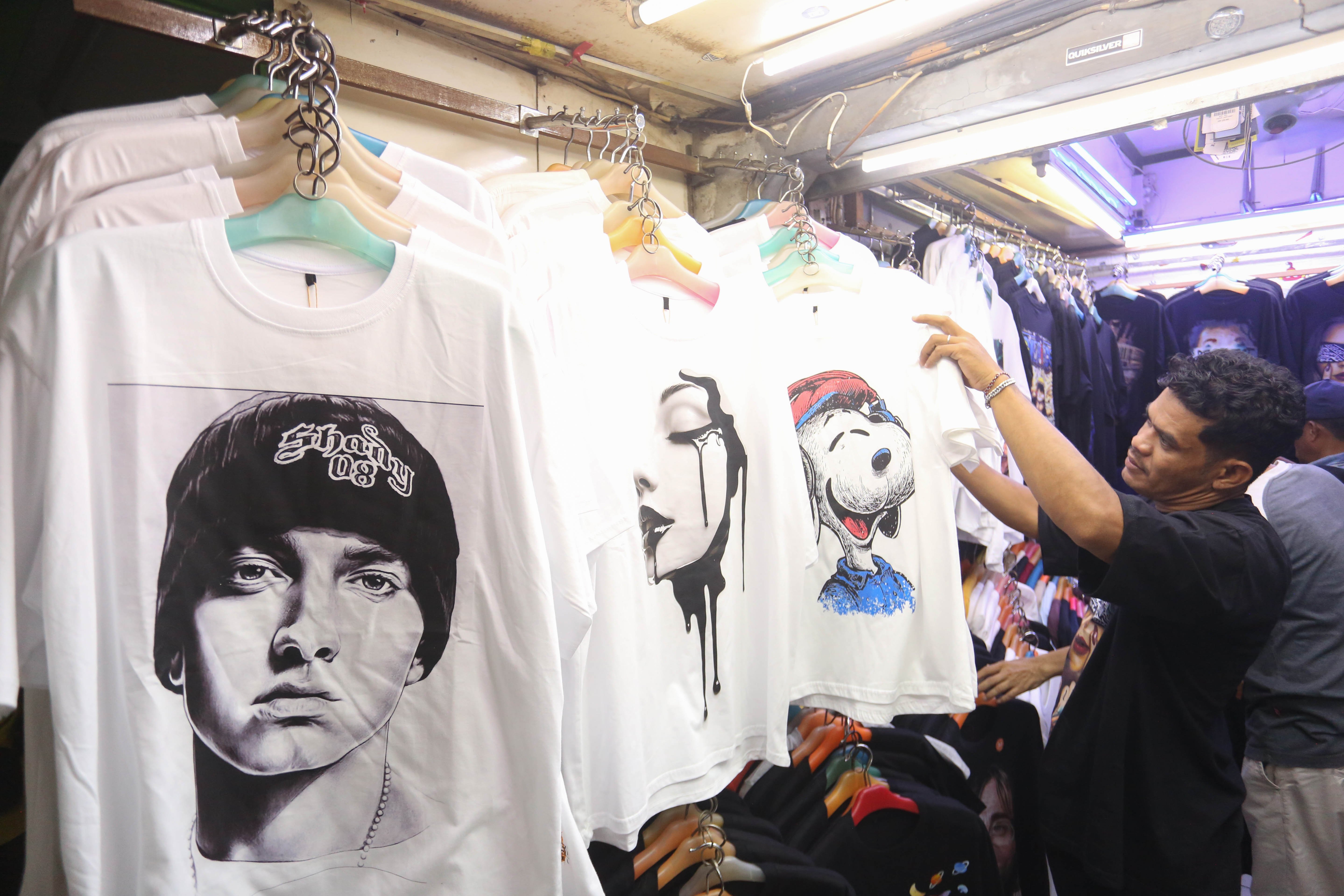 Calon pembeli melihat baju yang dijual di Pasar Ular, Koja, Jakarta Utara, Jumat (17/4/2026). Berdasarkan penuturan pedagang, sejak pandemi Covid-19 dan munculnya platform belanja online membuat penjualan barang dagangan di pasar tersebut menurun hingga 50 persen.