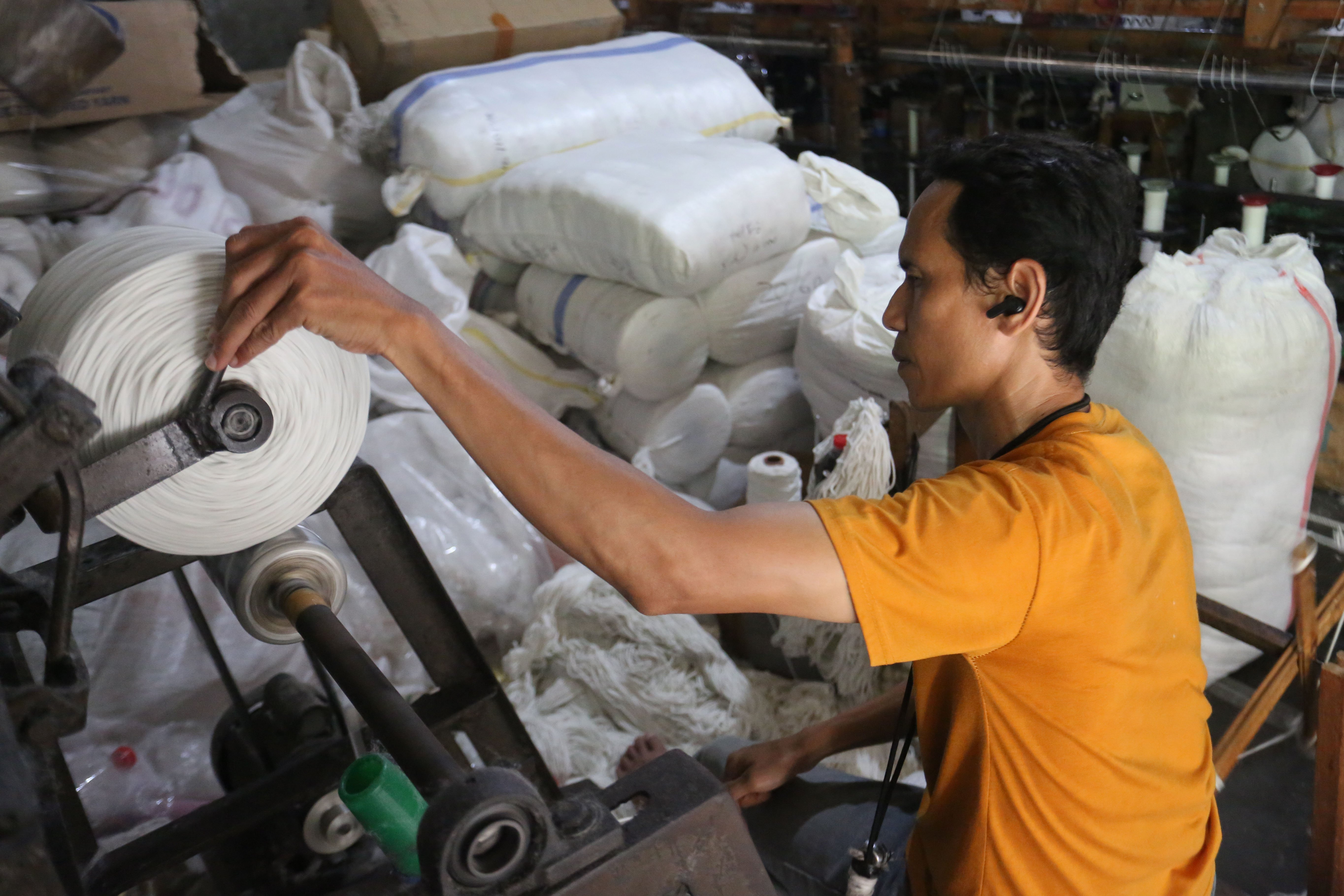 Pekerja memintal benang di Kebayoran Lama, Jakarta, Selasa (21/4/2026). Berdasarkan keterangan Saprudin (60) selaku pemilik usaha tersebut, harga bahan baku utama poliester yang melonjak berimbas pada naiknya harga benang katun dan poliester yang diproduksi ditempatnya mengalami kenaikan hingga Rp.2000 per kilogram.