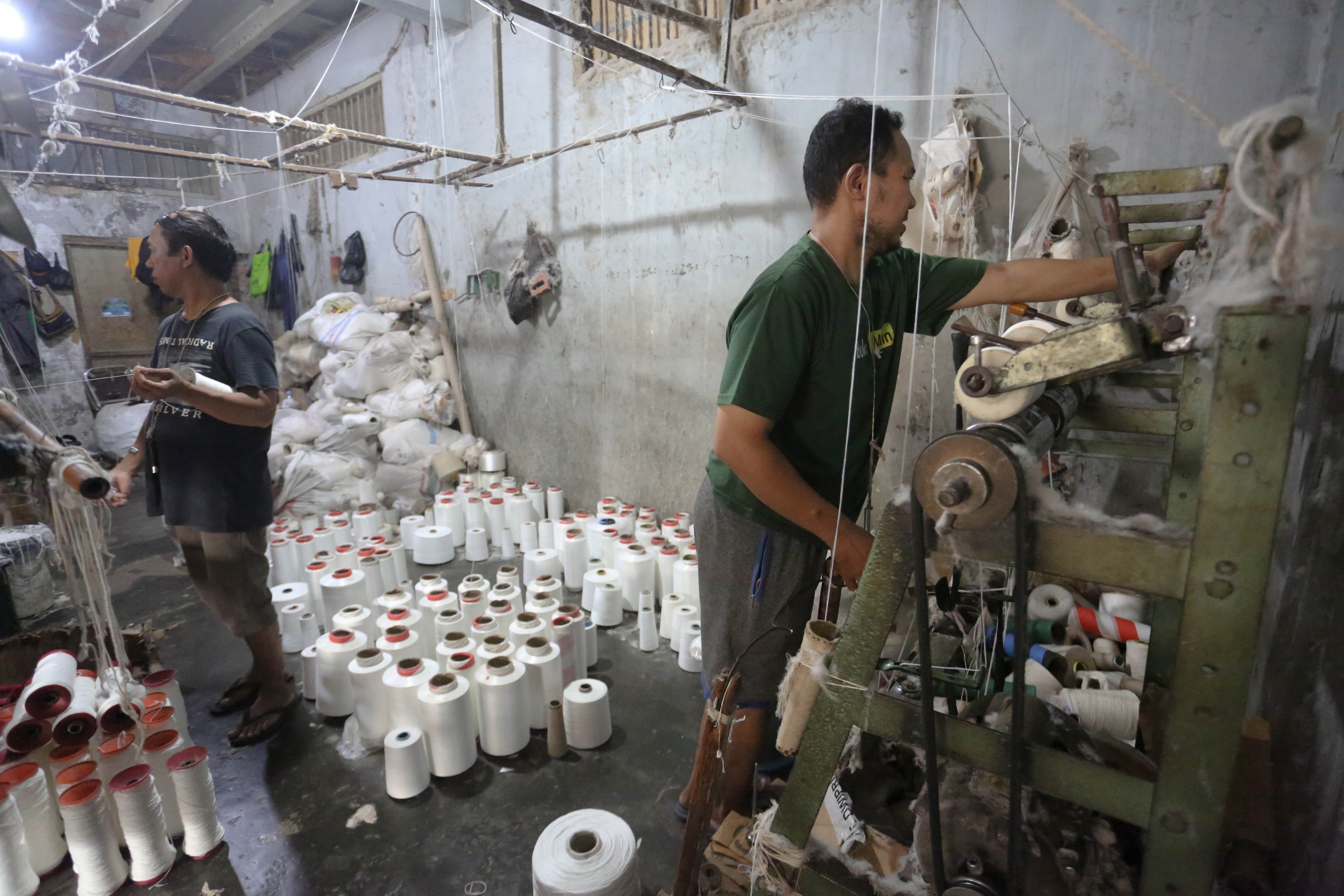 Pekerja memintal benang di Kebayoran Lama, Jakarta, Selasa (21/4/2026). Berdasarkan keterangan Saprudin (60) selaku pemilik usaha tersebut, harga bahan baku utama poliester yang melonjak berimbas pada naiknya harga benang katun dan poliester yang diproduksi ditempatnya mengalami kenaikan hingga Rp.2000 per kilogram.