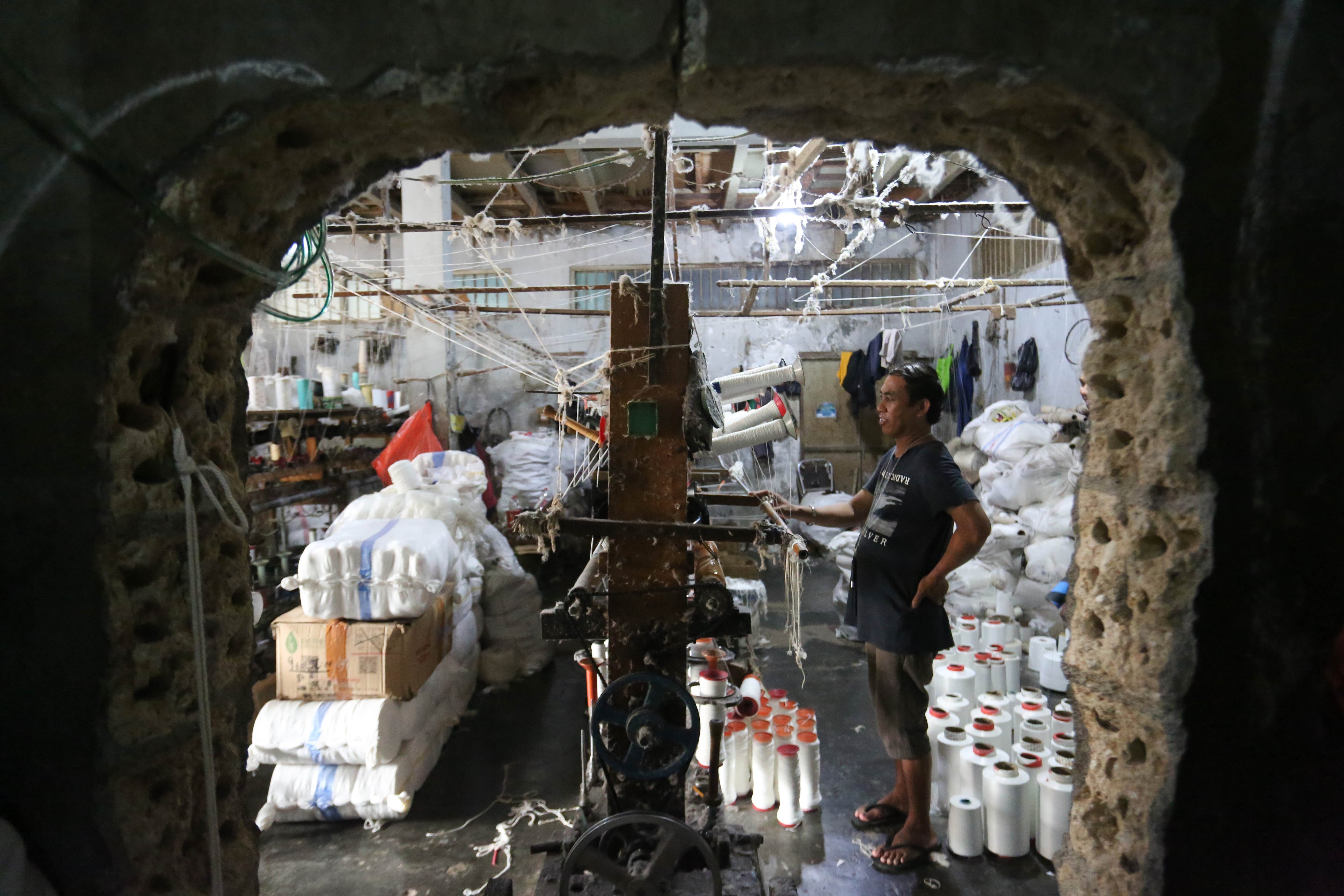 Pekerja memintal benang di Kebayoran Lama, Jakarta, Selasa (21/4/2026). Berdasarkan keterangan Saprudin (60) selaku pemilik usaha tersebut, harga bahan baku utama poliester yang melonjak berimbas pada naiknya harga benang katun dan poliester yang diproduksi ditempatnya mengalami kenaikan hingga Rp.2000 per kilogram.
