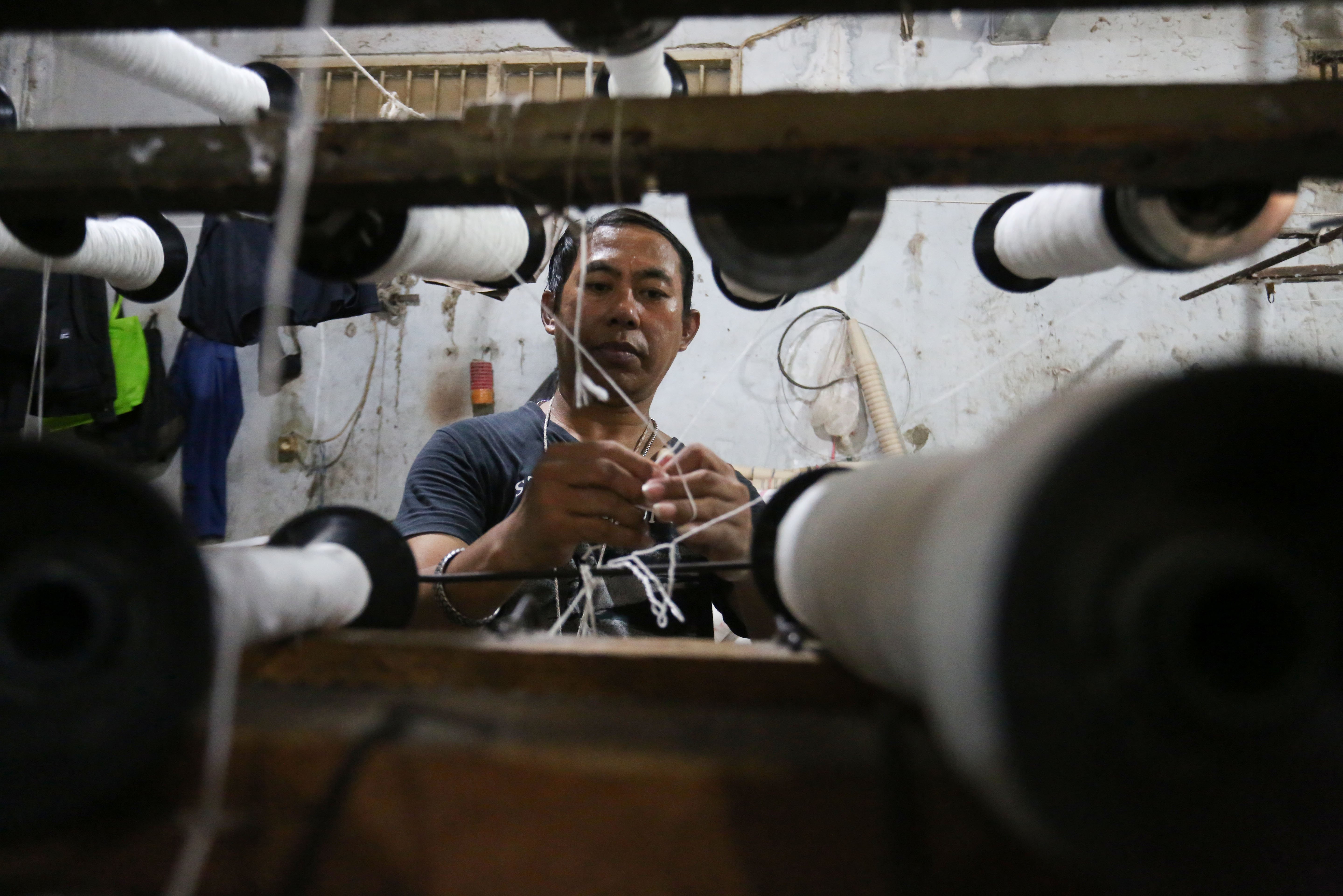 Pekerja memintal benang di Kebayoran Lama, Jakarta, Selasa (21/4/2026). Berdasarkan keterangan Saprudin (60) selaku pemilik usaha tersebut, harga bahan baku utama poliester yang melonjak berimbas pada naiknya harga benang katun dan poliester yang diproduksi ditempatnya mengalami kenaikan hingga Rp.2000 per kilogram.