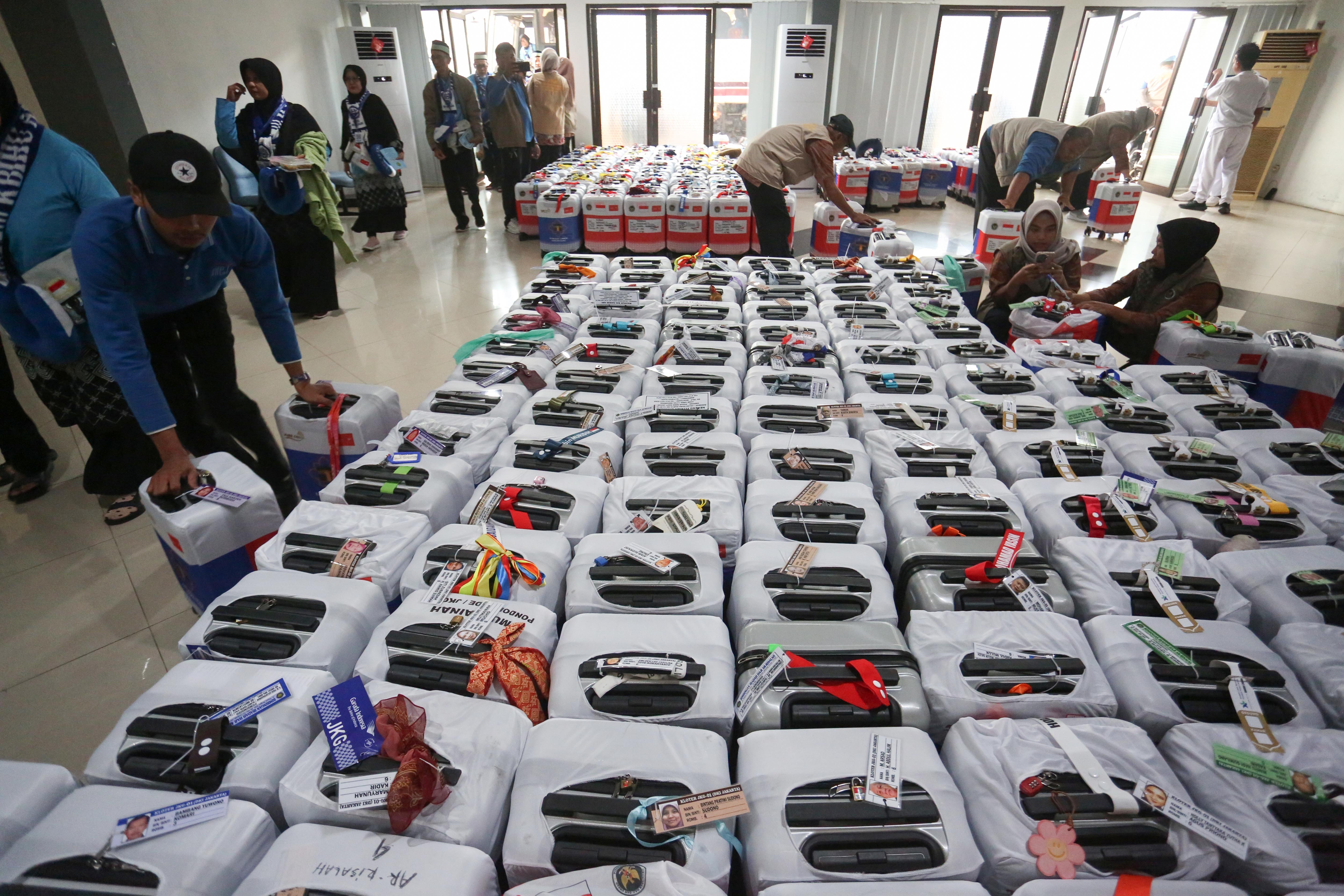 Petugas Penyelenggara Ibadah Haji (PPIH) menata koper milik jamaah calon haji di Asrama Haji Pondok Gede, Jakarta, Selasa (21/4/2026). Sebanyak 393 jamaah calon haji kloter pertama asal Jakarta mengikuti pemeriksaan administrasi dan kesehatan sebelum diberangkatkan ke tanah suci pada 22 April 2026.