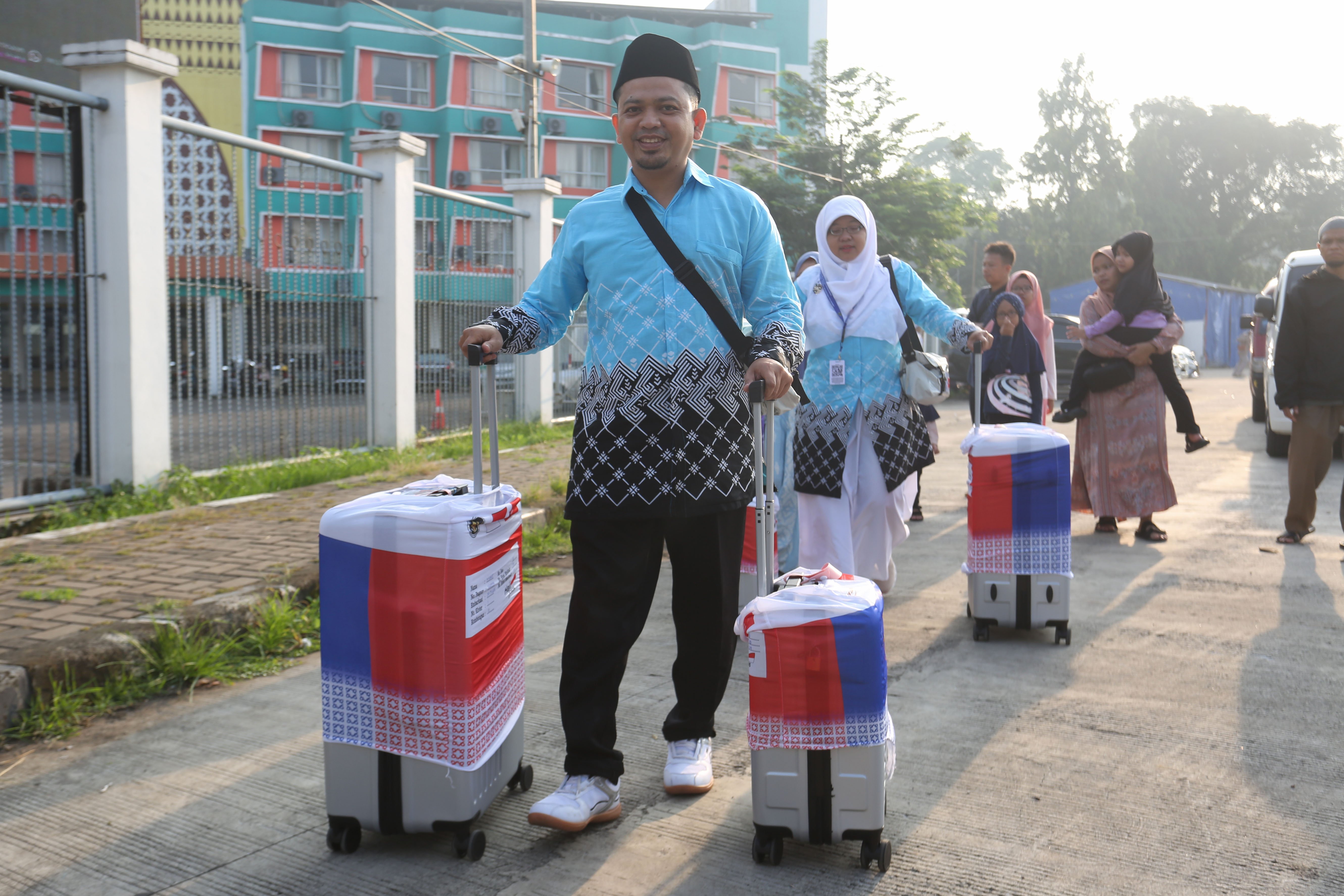 Jamaah calon haji membawa koper setibanya di Asrama Haji Pondok Gede, Jakarta, Selasa (21/4/2026). Sebanyak 393 jamaah calon haji kloter pertama asal Jakarta mengikuti pemeriksaan administrasi dan kesehatan sebelum diberangkatkan ke tanah suci pada 22 April 2026.