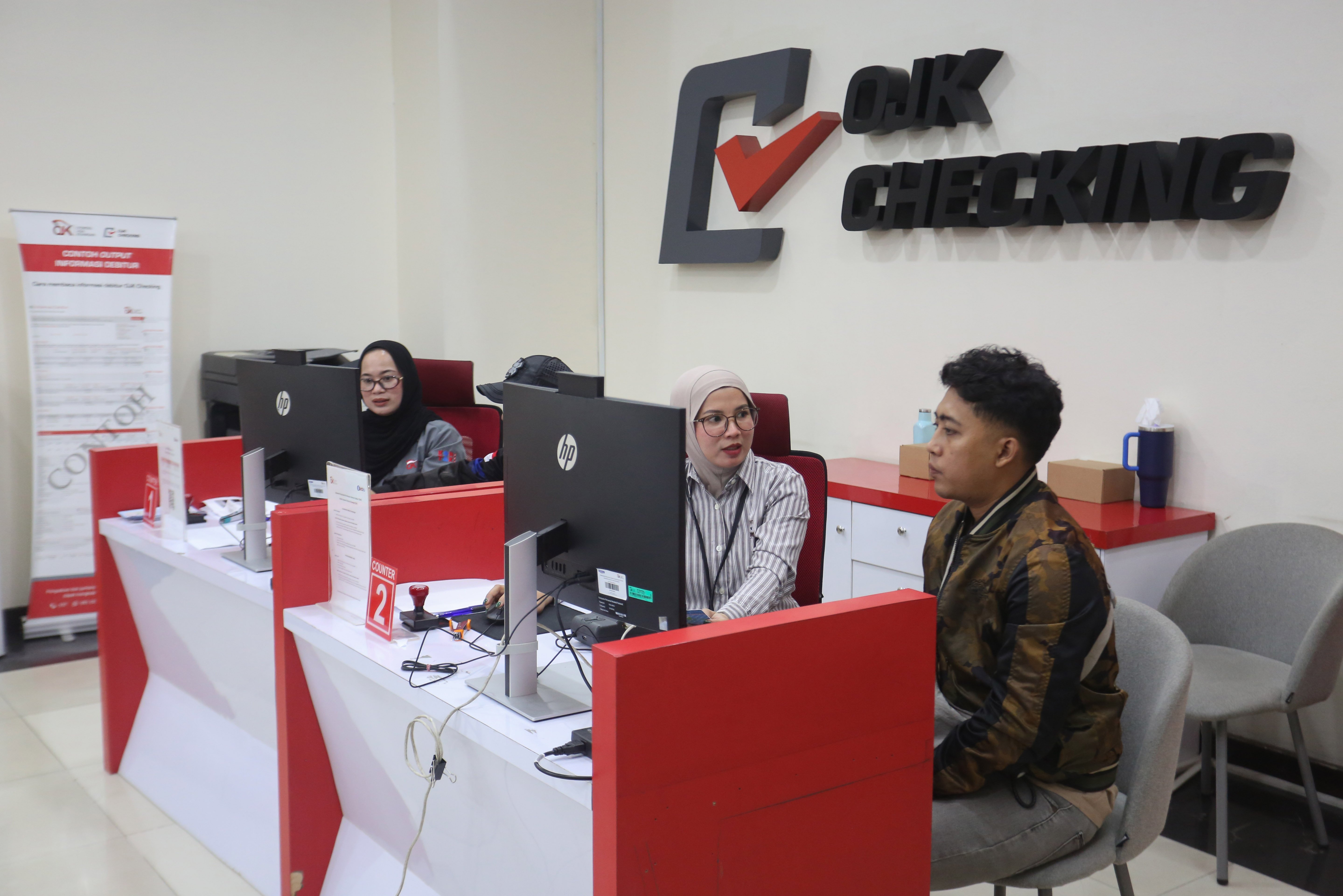 Petugas melayani warga untuk mengecek catatan kredit melalui Sistem Layanan Informasi Keuangan (SLIK) di Kantor Otoritas Jasa Keuangan, Jakarta, Rabu (22/4/2026). Kementerian Perumahan dan Kawasan Permukiman bersama Otoritas Jasa Keuangan mengeluarkan kebijakan baru yakni masyarakat dengan catatan kredit sebesar Rp 1 juta ke bawah di Sistem Layanan Informasi Keuangan (SLIK) dapat mengajukan kredit rumah subsidi.