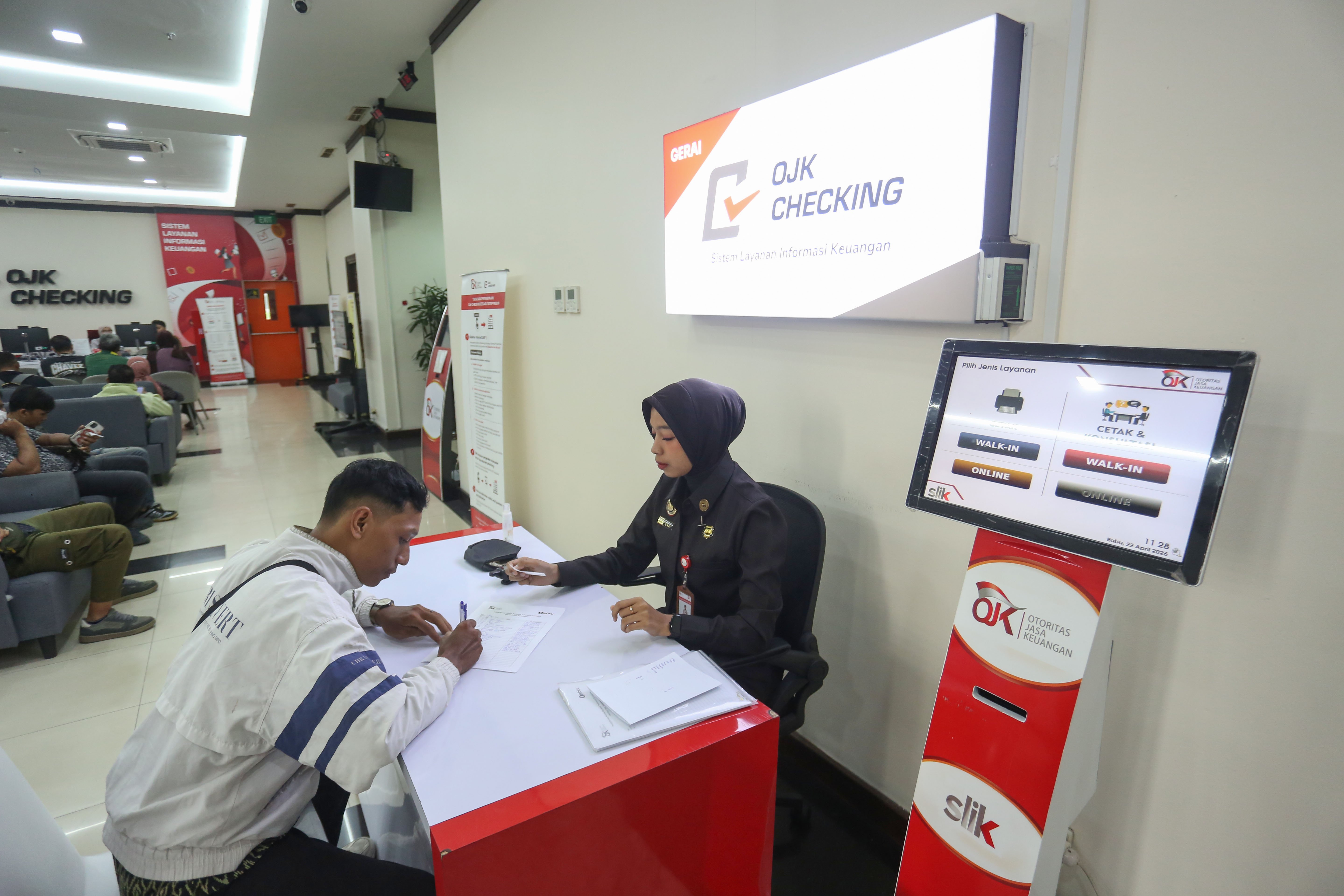 Petugas melayani warga yang hendak mengecek catatan kredit melalui Sistem Layanan Informasi Keuangan (SLIK) di Kantor Otoritas Jasa Keuangan, Jakarta, Rabu (22/4/2026). Kementerian Perumahan dan Kawasan Permukiman bersama Otoritas Jasa Keuangan mengeluarkan kebijakan baru yakni masyarakat dengan catatan kredit sebesar Rp 1 juta ke bawah di Sistem Layanan Informasi Keuangan (SLIK) dapat mengajukan kredit rumah subsidi.