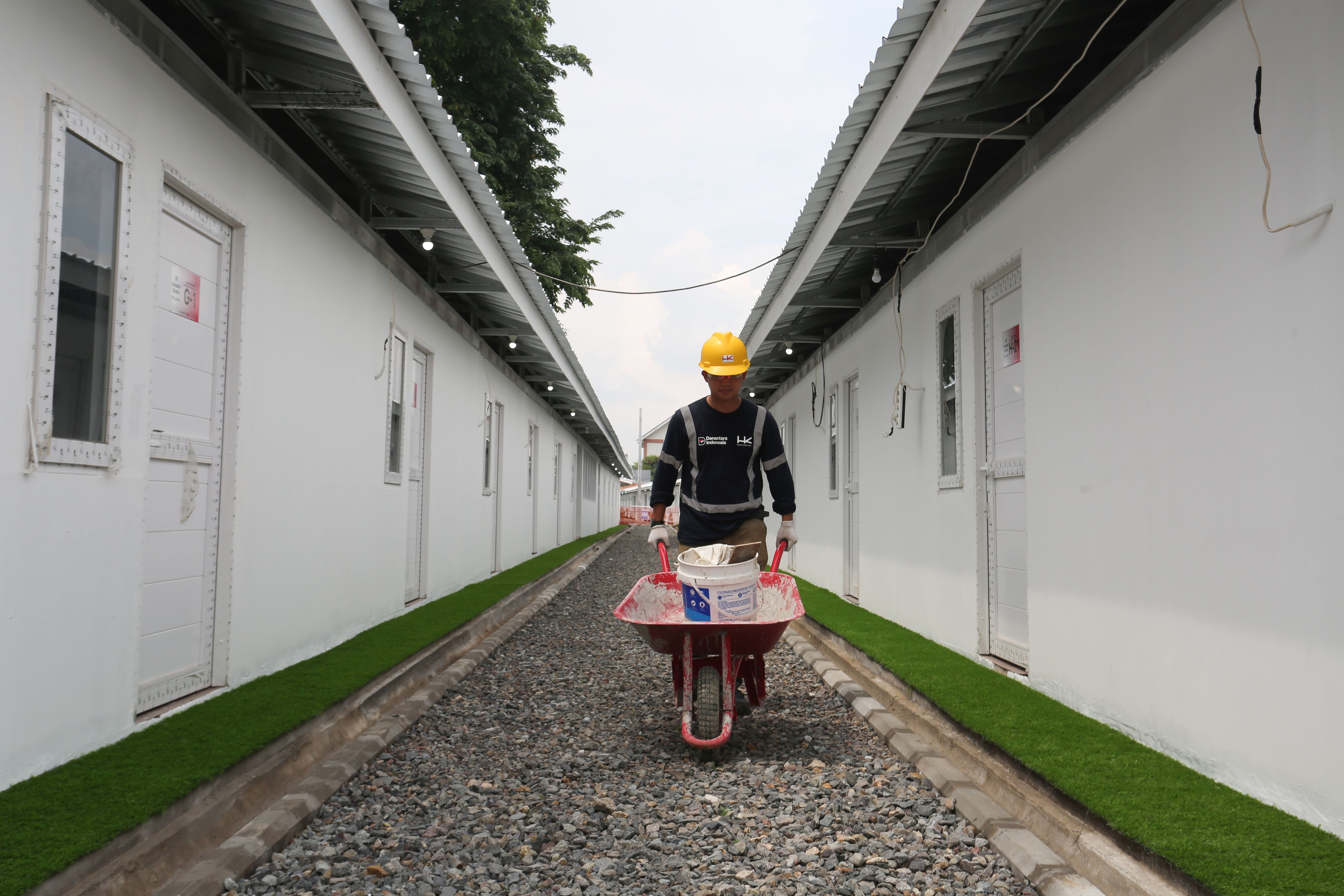 Pekerja mengangkut alat kerja untuk menyelesaikan pembangunan hunian layak di kawasan Senen, Jakarta, Kamis (23/4/2026). Kementerian Perumahan dan Kawasan Permukiman (PKP) membangun 324 unit rumah yang dilengkapi fasilitas seperti dapur umum, toilet komunal dan musala untuk warga yang tinggal di bantaran rel kereta api Pasar Senen.