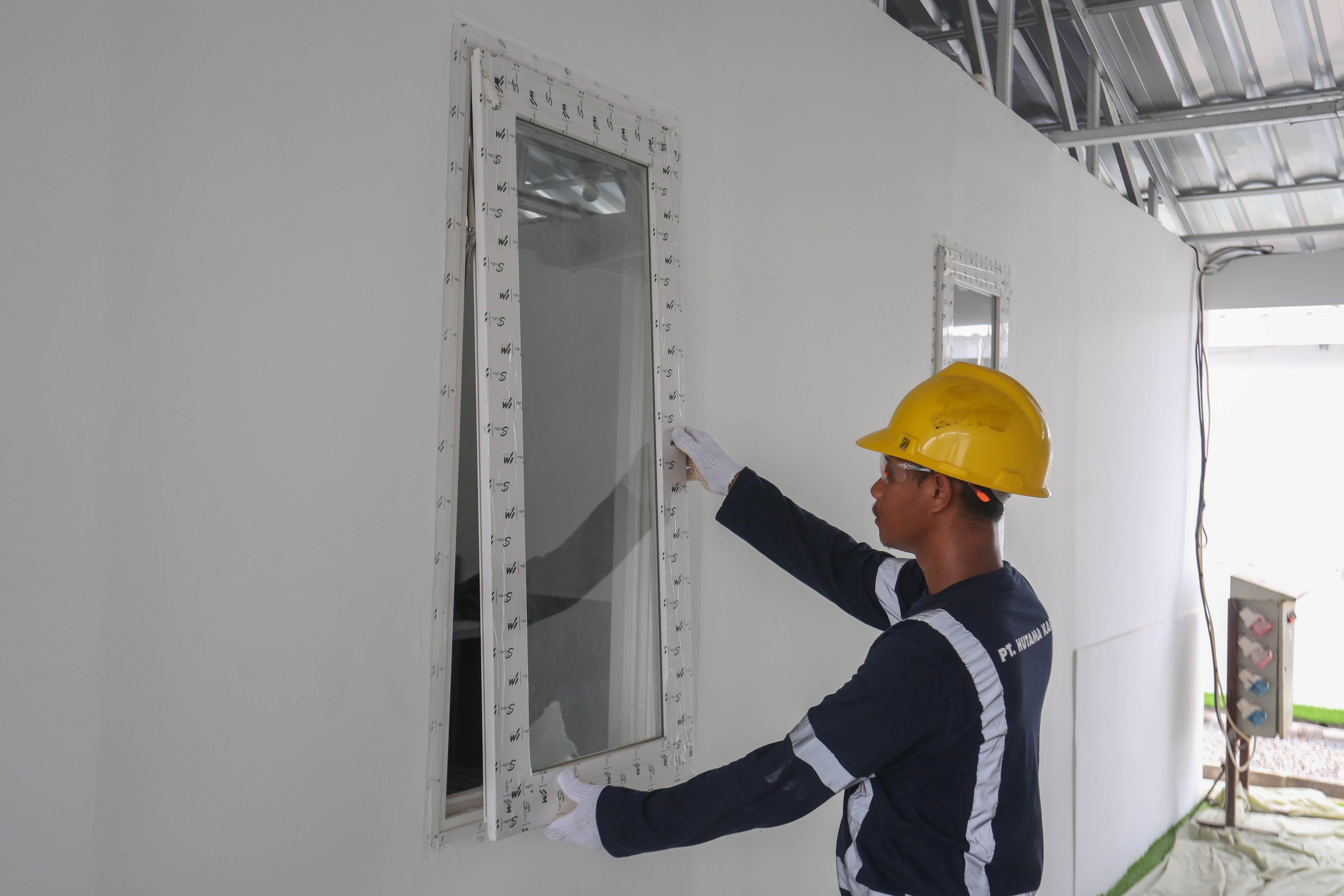 Pekerja memasang jendela saat pembangunan hunian layak di kawasan Senen, Jakarta, Kamis (23/4/2026). Kementerian Perumahan dan Kawasan Permukiman (PKP) membangun 324 unit rumah yang dilengkapi fasilitas seperti dapur umum, toilet komunal dan musala untuk warga yang tinggal di bantaran rel kereta api Pasar Senen. 