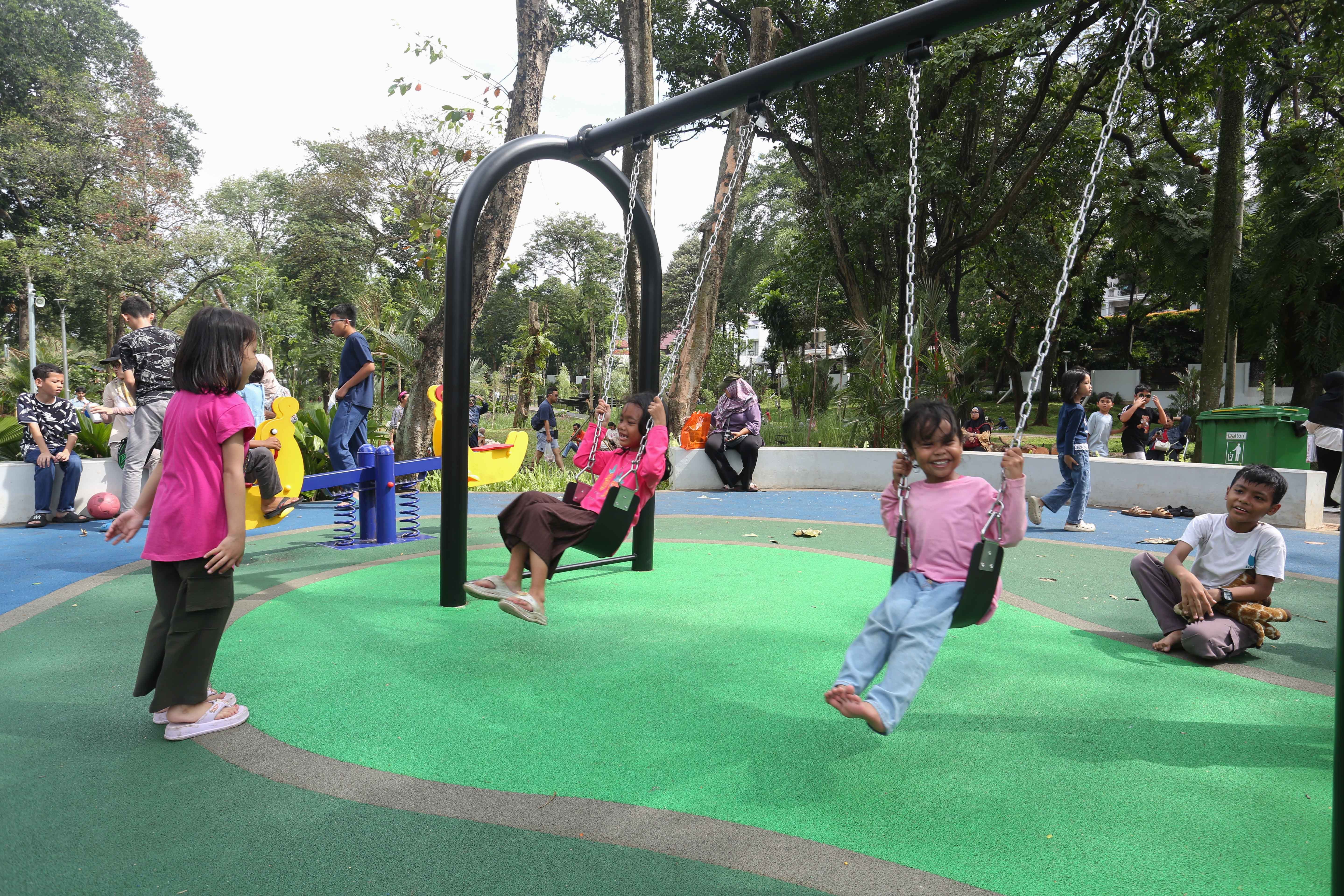 Sejumlah anak bermain di area Taman Bendera Pusaka, Kebayoran Baru, Jakarta Selatan, Sabtu (25/4/2026). Taman seluas 5,6 hektare yang menawarkan suasana asri dan dilengkapi dengan fasilitas seperti area piknik, lapangan olahraga, hingga tempat bermain anak ini menjadi destinasi wisata baru bagi masyarakat dalam menghabiskan waktu akhir pekan.