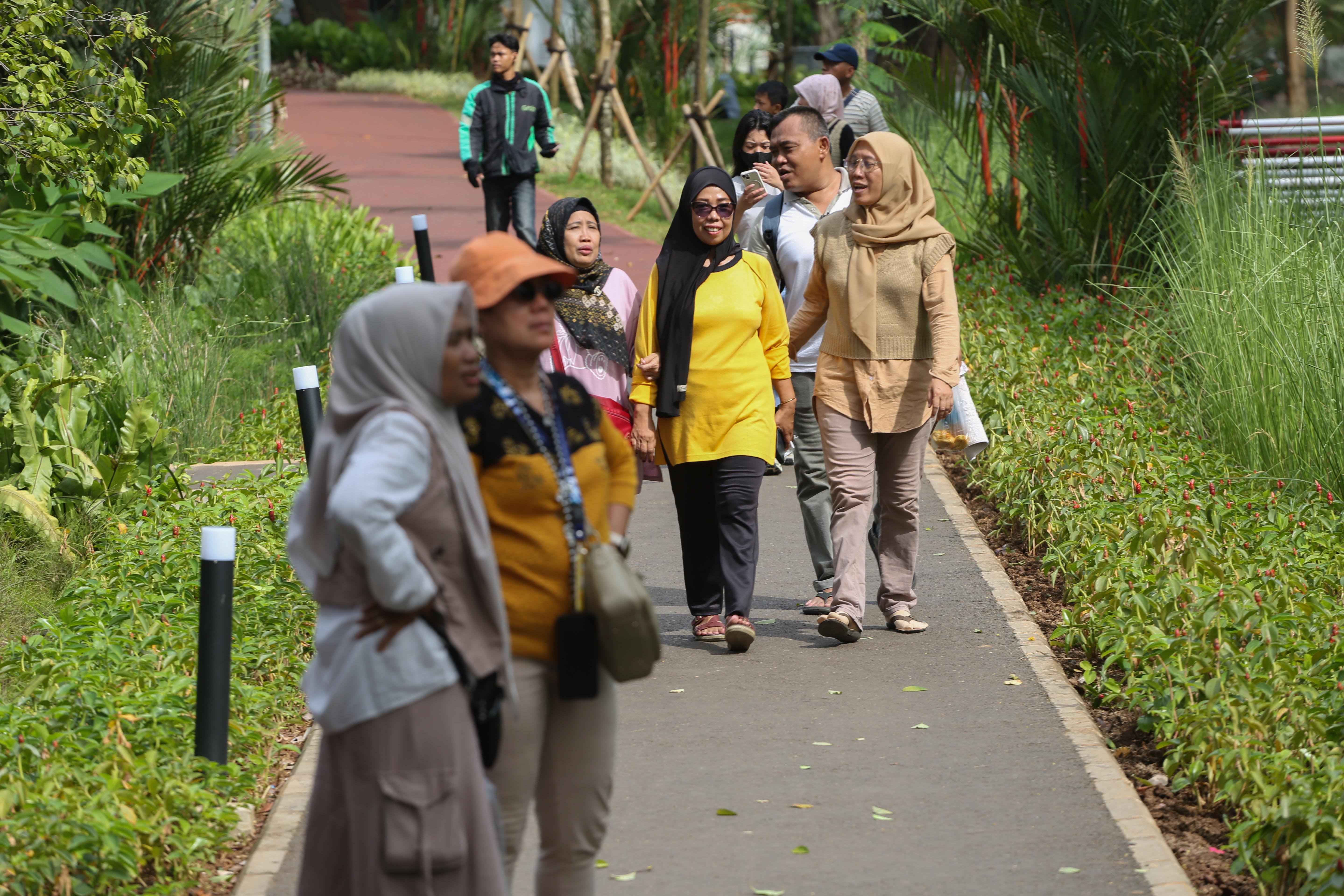 Warga berjalan di Taman Bendera Pusaka, Kebayoran Baru, Jakarta Selatan, Sabtu (25/4/2026). Taman seluas 5,6 hektare yang menawarkan suasana asri dan dilengkapi dengan fasilitas seperti area piknik, lapangan olahraga, hingga tempat bermain anak ini menjadi destinasi wisata baru bagi masyarakat dalam menghabiskan waktu akhir pekan.